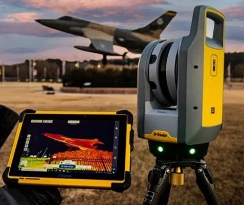 A 3d Scanner capturing the environment, with a tablet showing the data behind it