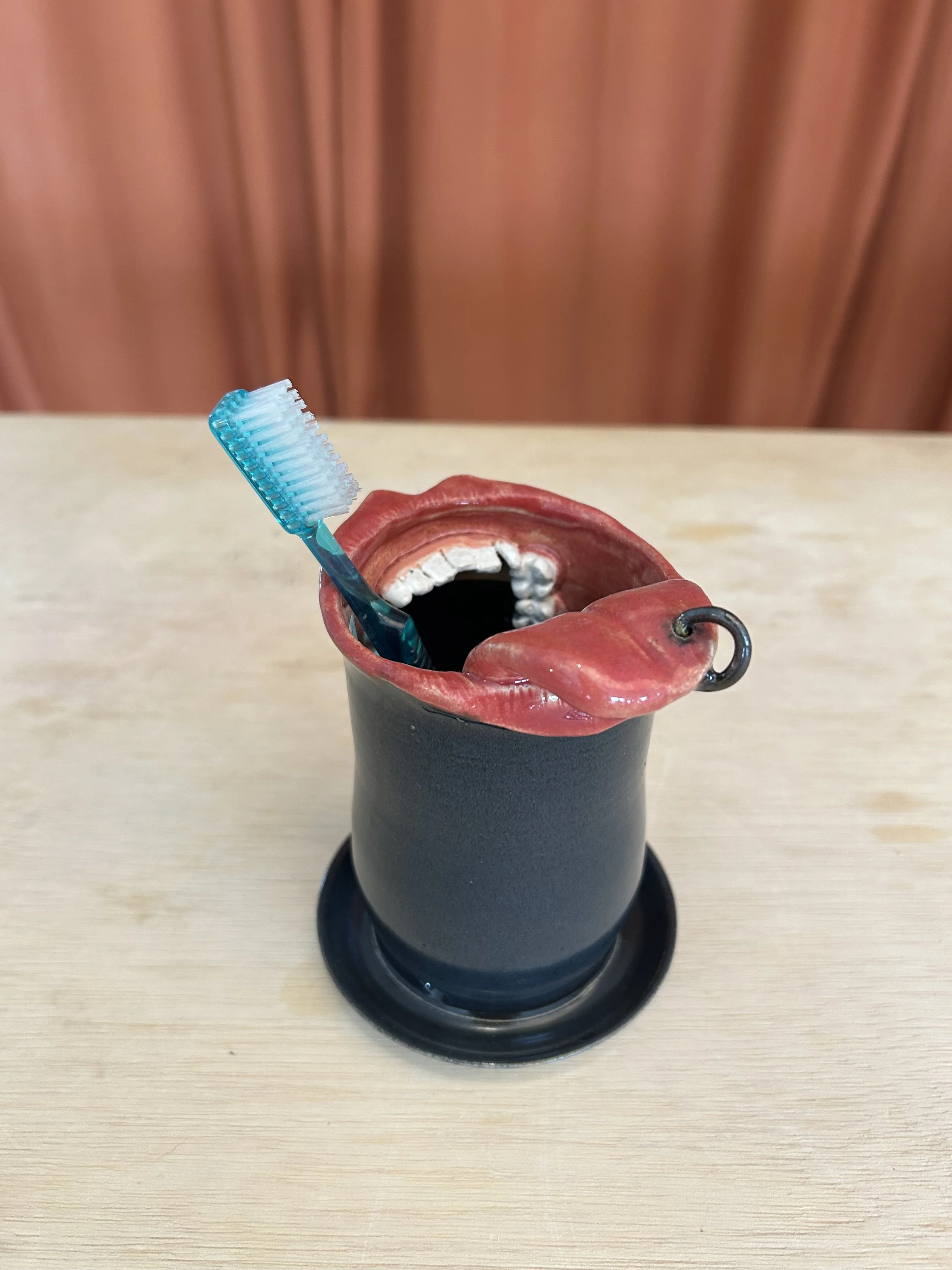 Toothbrush Holder with tongue piercing.