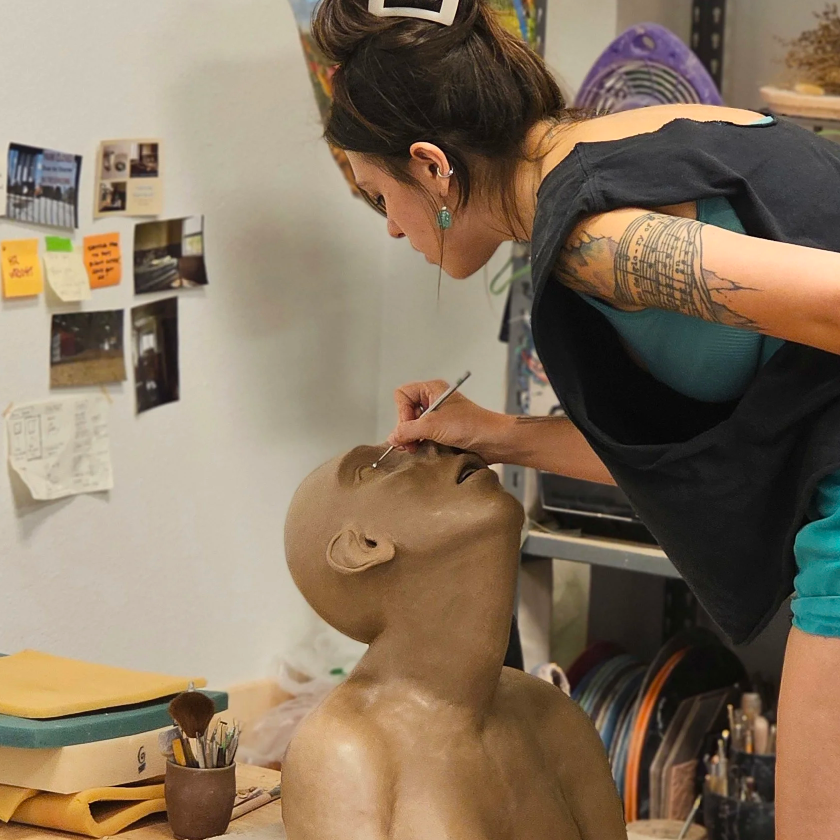 Woman working on ceramic bust sculpture of a woman