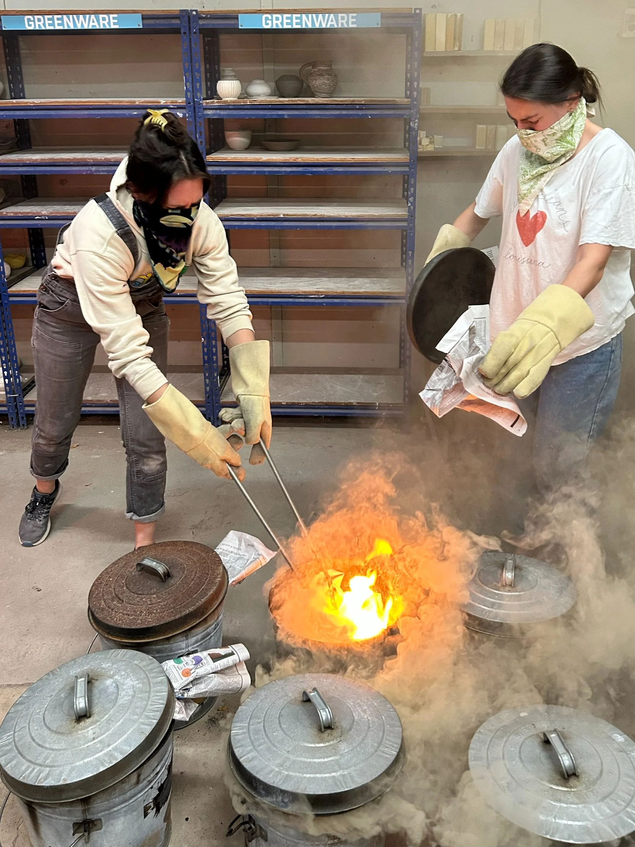 two women completing a ceramic raku firing