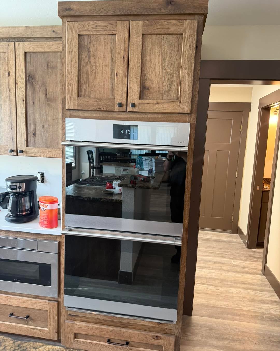This kitchen cabinetry brings warmth, function, and craftsmanship together with rich wood tones, clean paneling, and thoughtful storage built right into the design. From the appliance surround to the vertical tray dividers, every piece was made to fe