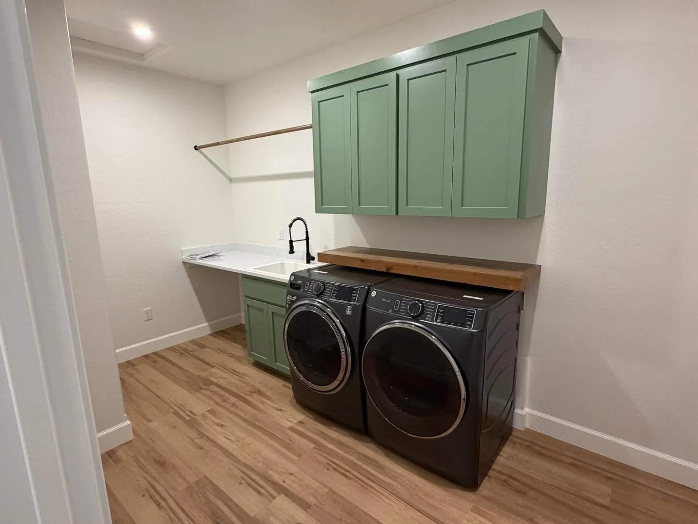 Andorandak green done right.

Custom cabinetry by Cabinetree brings warmth and character to this laundry space, paired with natural wood countertops and clean lines for a look that feels elevated yet functional. A utility room doesn&rsquo;t have to b