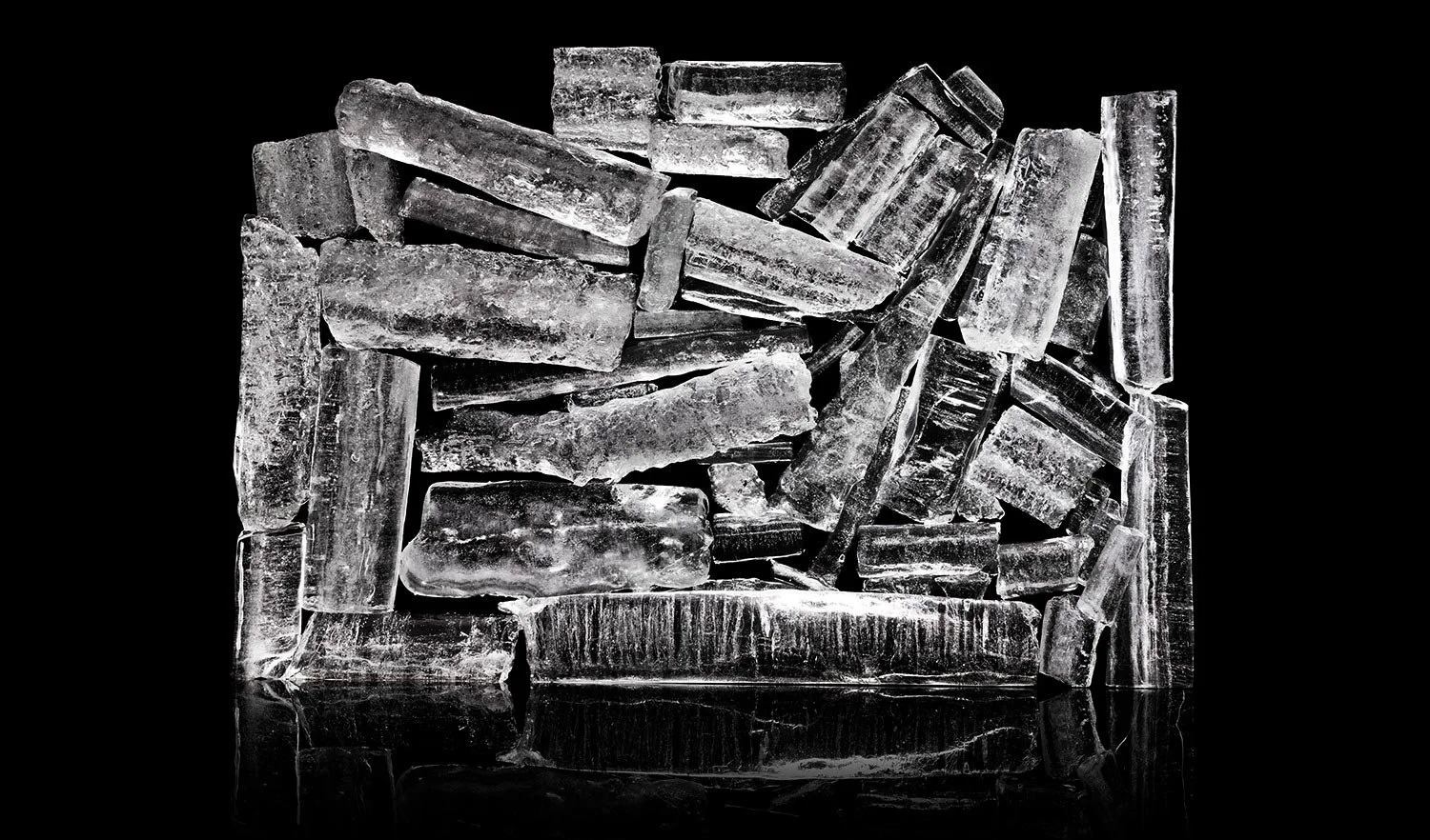 Ice cubes stacked on each other against a black background.