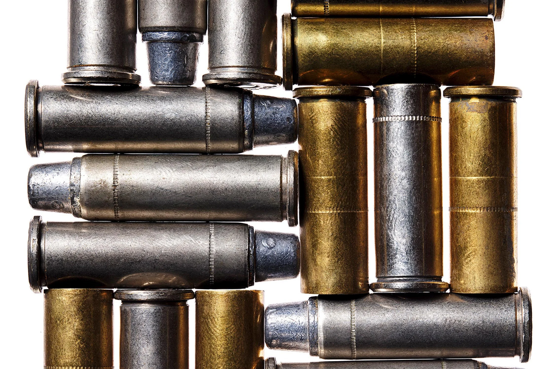 Collection of metal bullet cartridges with silver and brass finishes arranged in a pattern