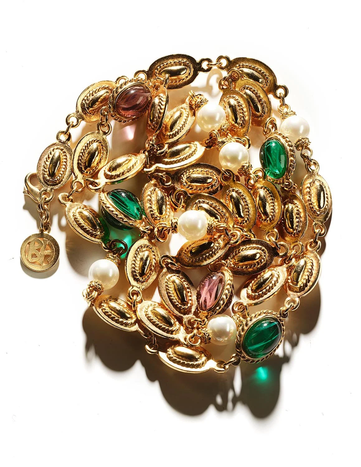 Gold necklace with multicolored oval and round gemstones, including green, pink, and white pearls, on a white background.