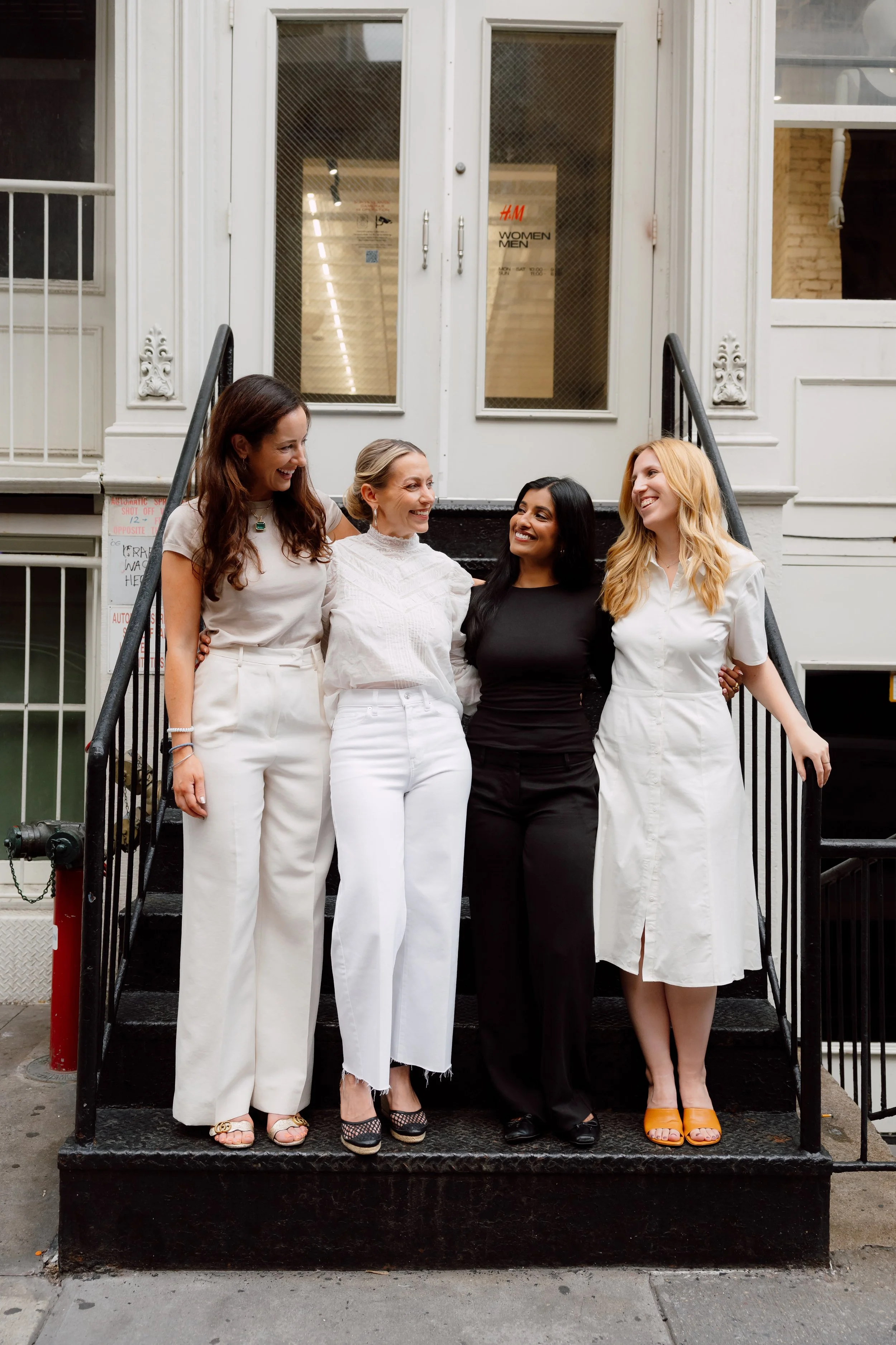 Four femal therapists standing closely together on the stoop of a building that is clearly in Soho NYC