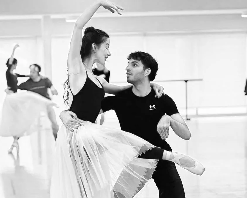Ballet dancer practicing with a male instructor in a dance studio