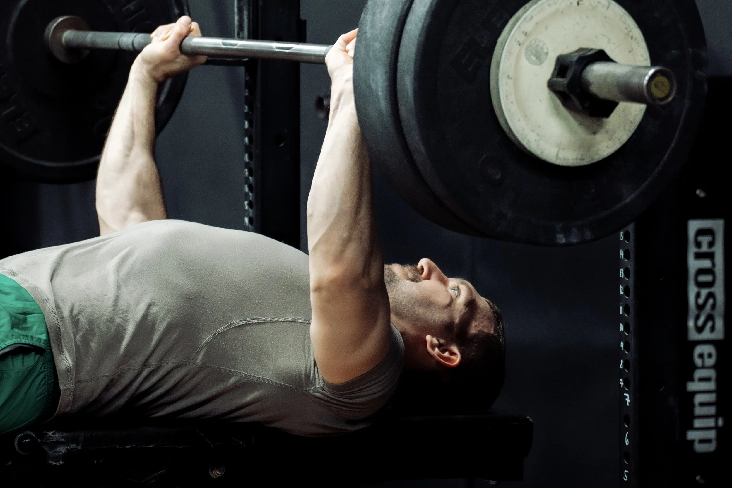 Athlete performing a strength training exercise benchpress with a barbell