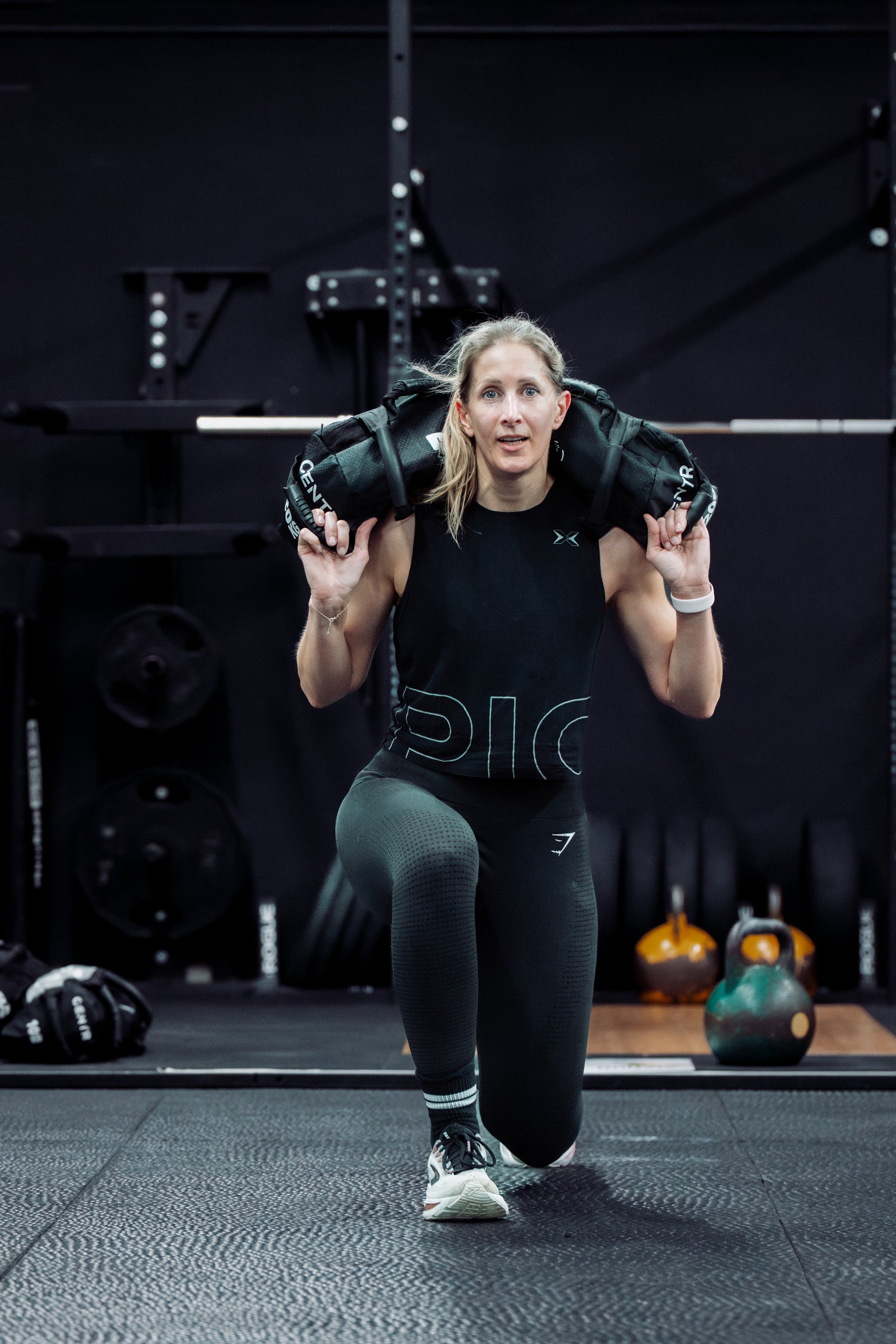 woman doing the hyrox movement sandbag lunges
