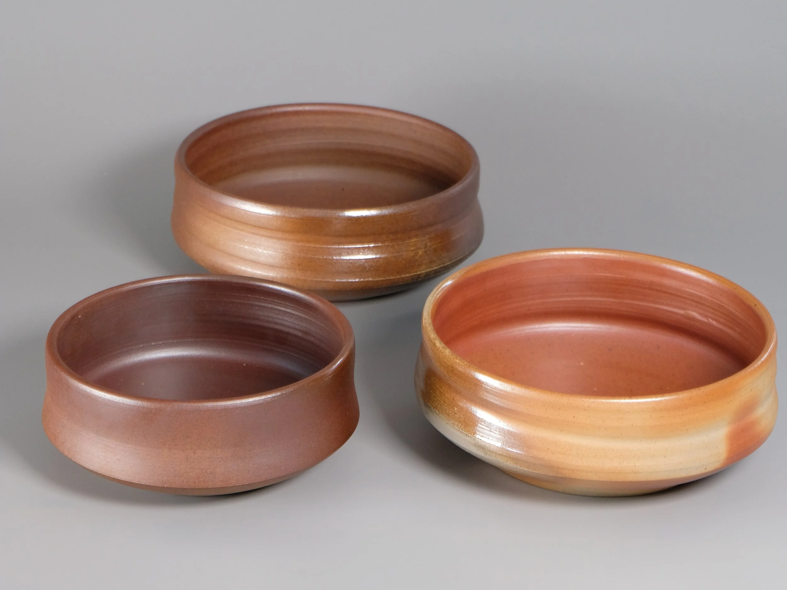 Dype serveringsfat eller salatboller i steingods. Vedbrent i varme nyanser og subtil flashing