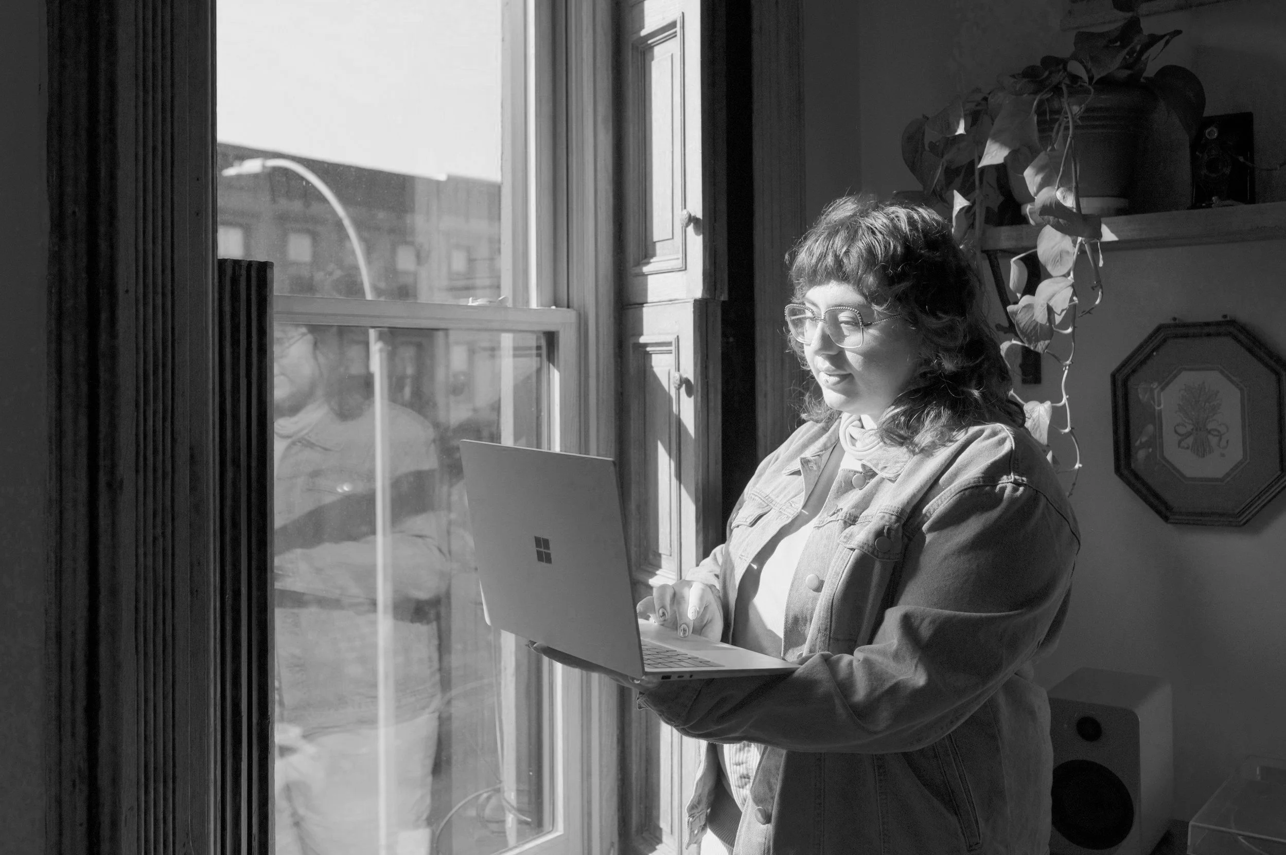 Woman holding laptop by the window