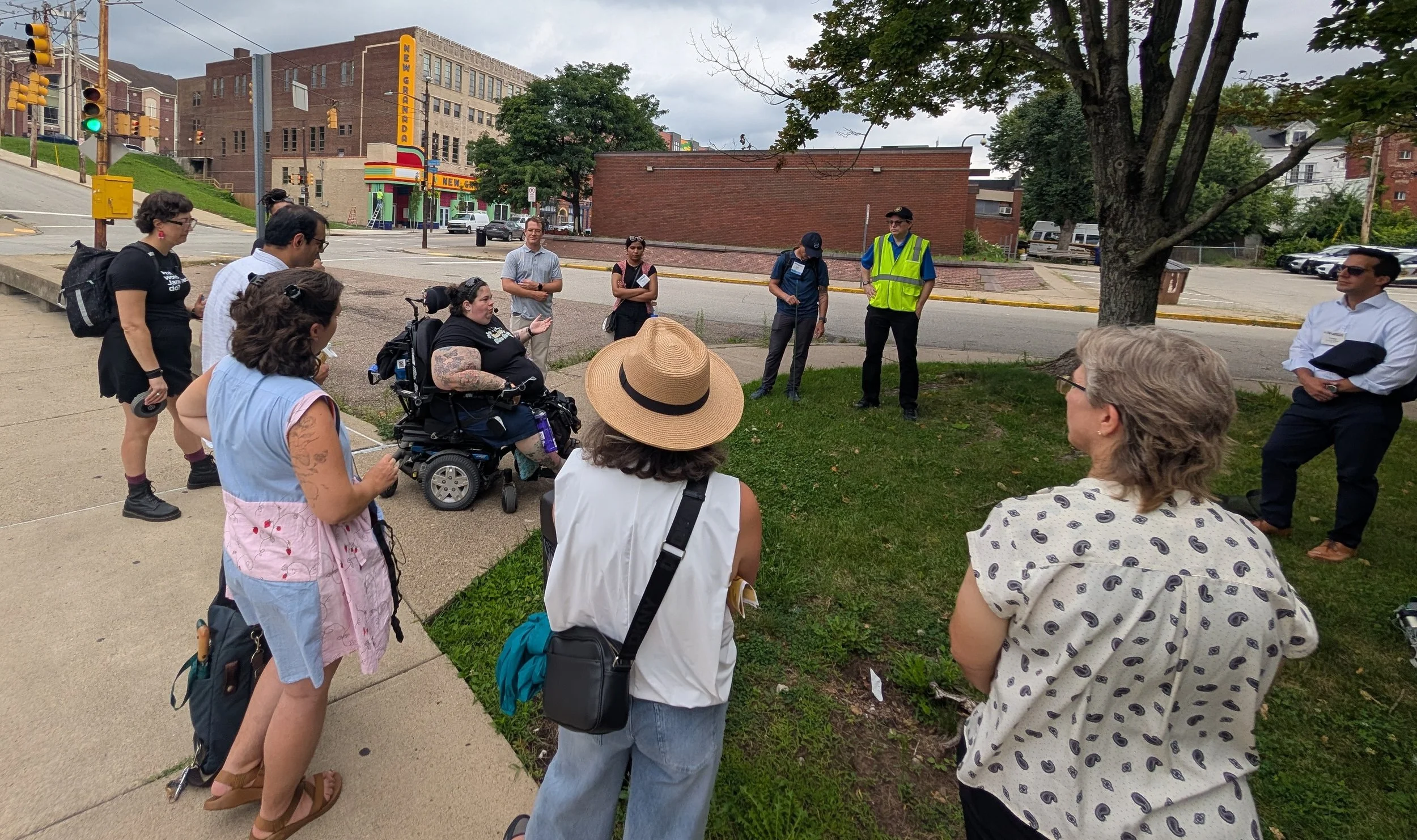 People gather on a street corner to learn about sidewalk issues and how Pittsburgh Walks is addressing them.