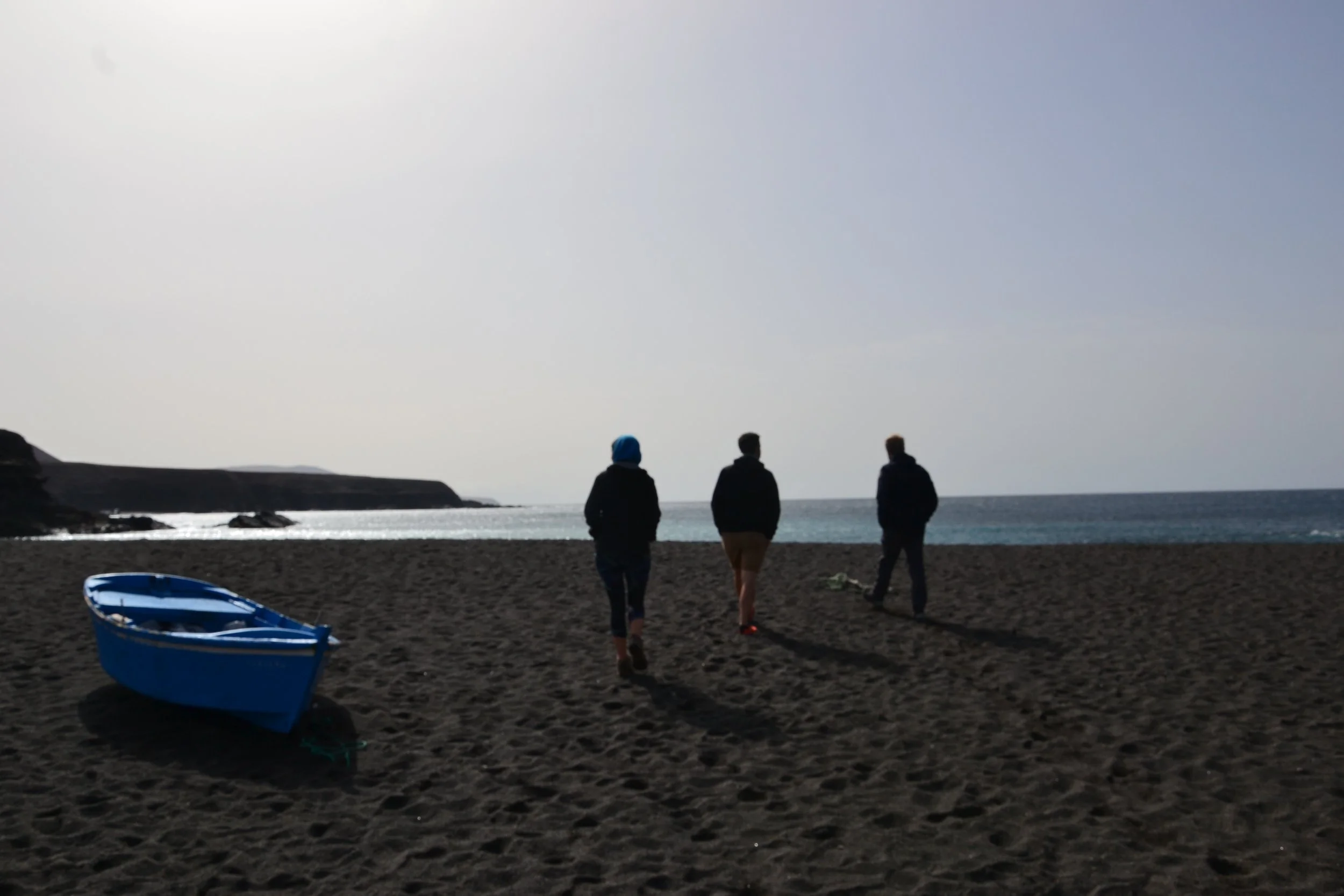 3 voyageurs slow à Fuerteventura, îles canaries, sur une plage de sable noir