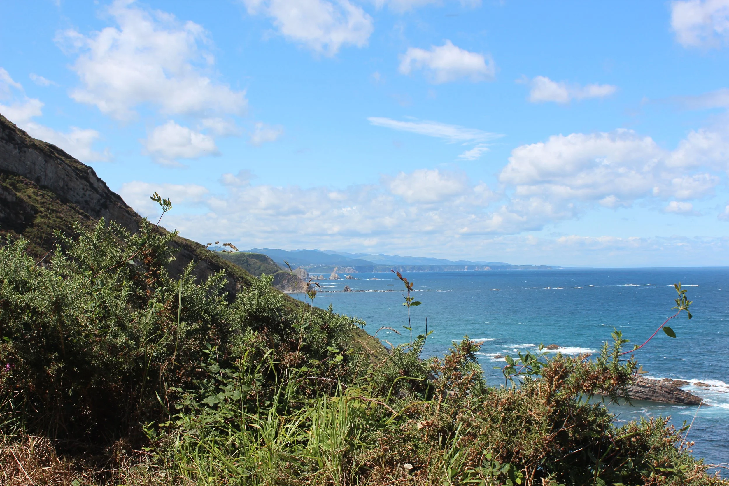 Vue depuis la côte Nord Espagnole, Les Asturies, Océan bleu et montagnes au loin.