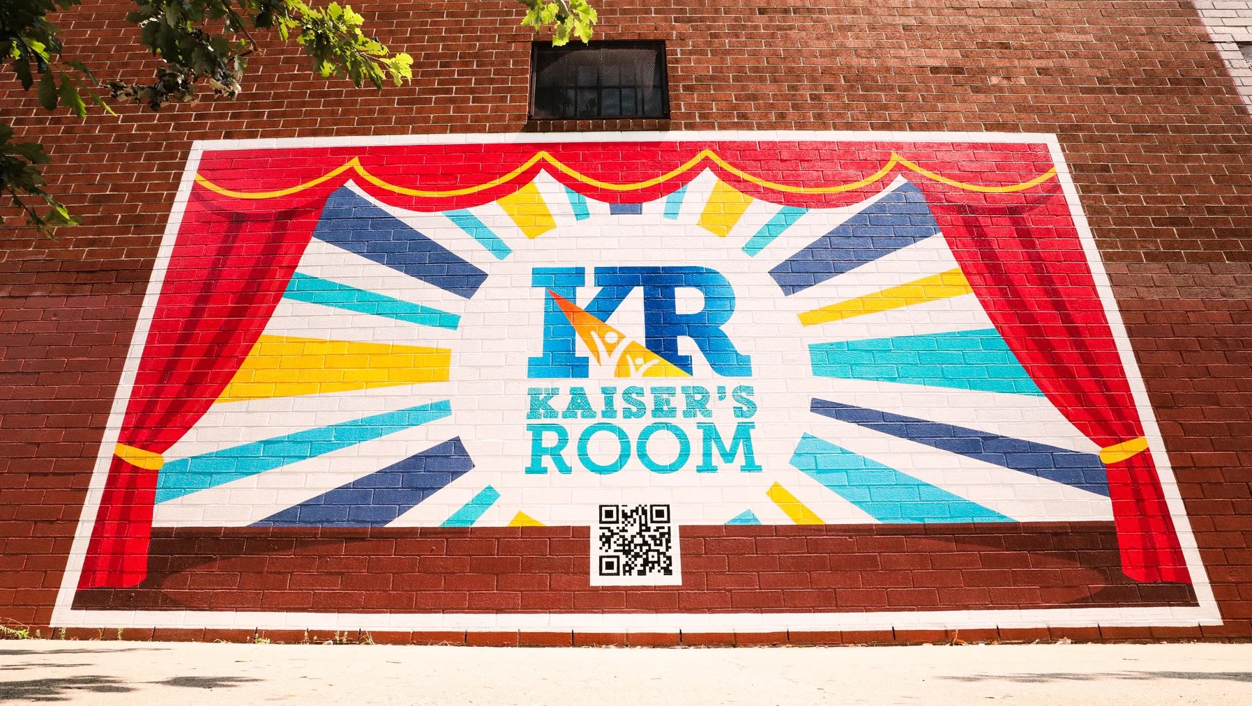 Kaiser’s Room mural in Williamsburg, Brooklyn hand-painted by Colossal Media. The mural is a painted stage with red curtains featuring the Kaiser's Room mural and a QR code.