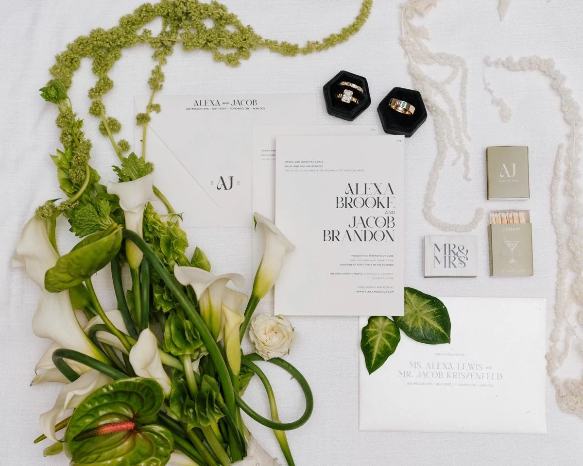 Wedding invitation suite with floral arrangements, rings, and small boxes for wedding accessories.