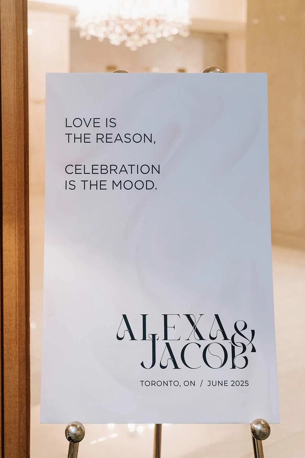 Wedding sign with a quote about love and celebration, featuring the names Alexa and Jacob, indicating a wedding event in Toronto in June 2025.