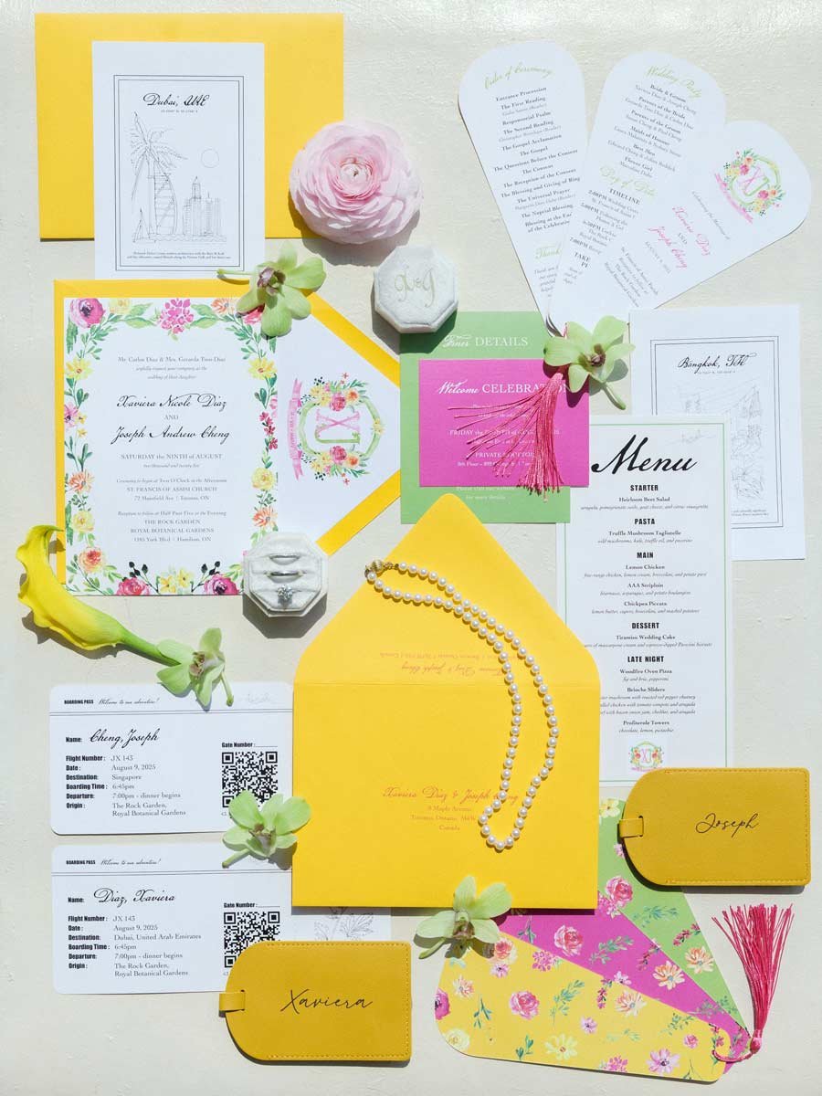 A collection of wedding or event invitations, tickets, and stationery in various colors and floral designs. Includes a pink welcome sign, yellow envelopes, a pearl necklace, and decorative flowers.