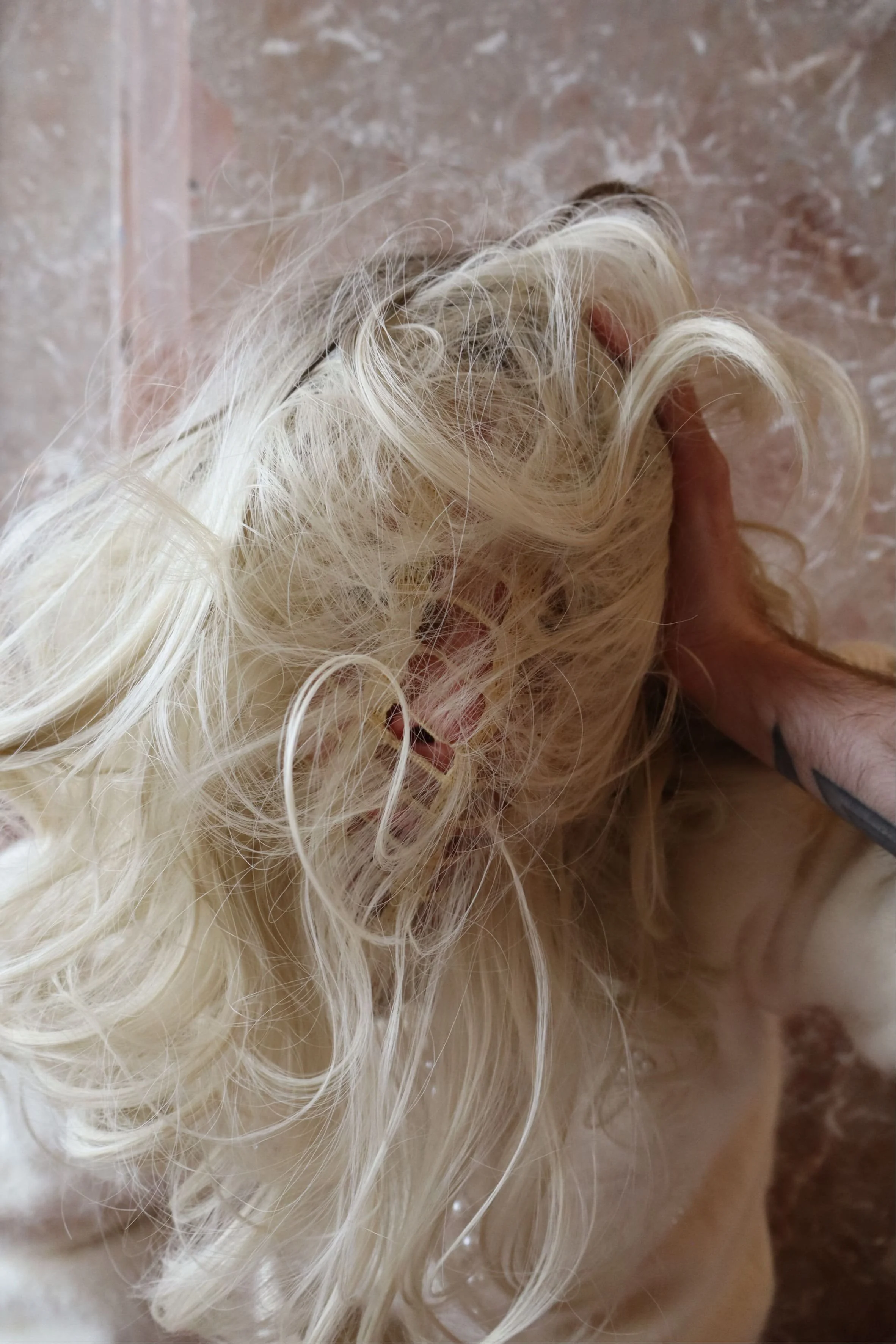 Close-up of performer with expressive hair partially covering the face - Ave Vanilla performance art