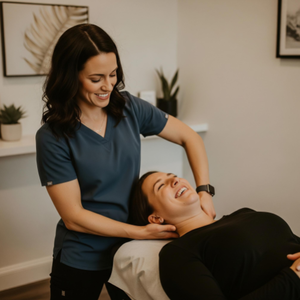 A chiropractor providing an adjustment to a happy, pain-free patient in a modern and clean treatment room.