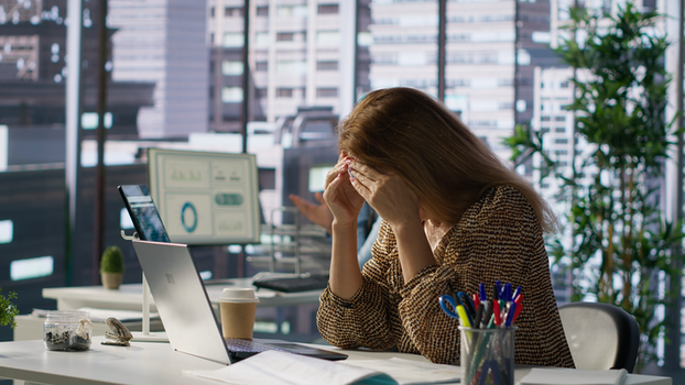 A person looking stressed while reviewing a pile of receipts and documents