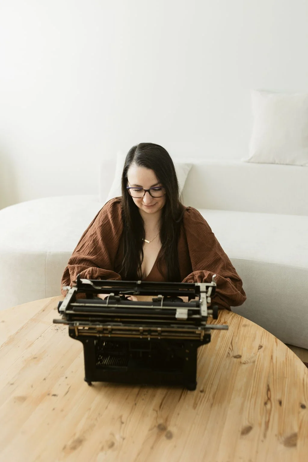 Sarah sitting on the floor, typing on a keyboard thinking about how you should act like you're traditionally publishing when you're self-publishing