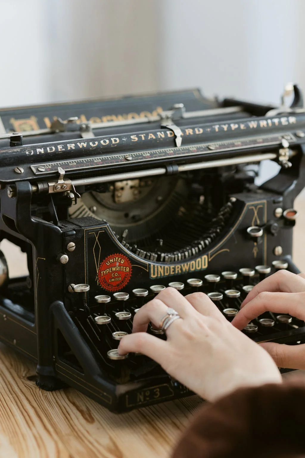 Turning your content into your first book – hands typing on a black typewriter