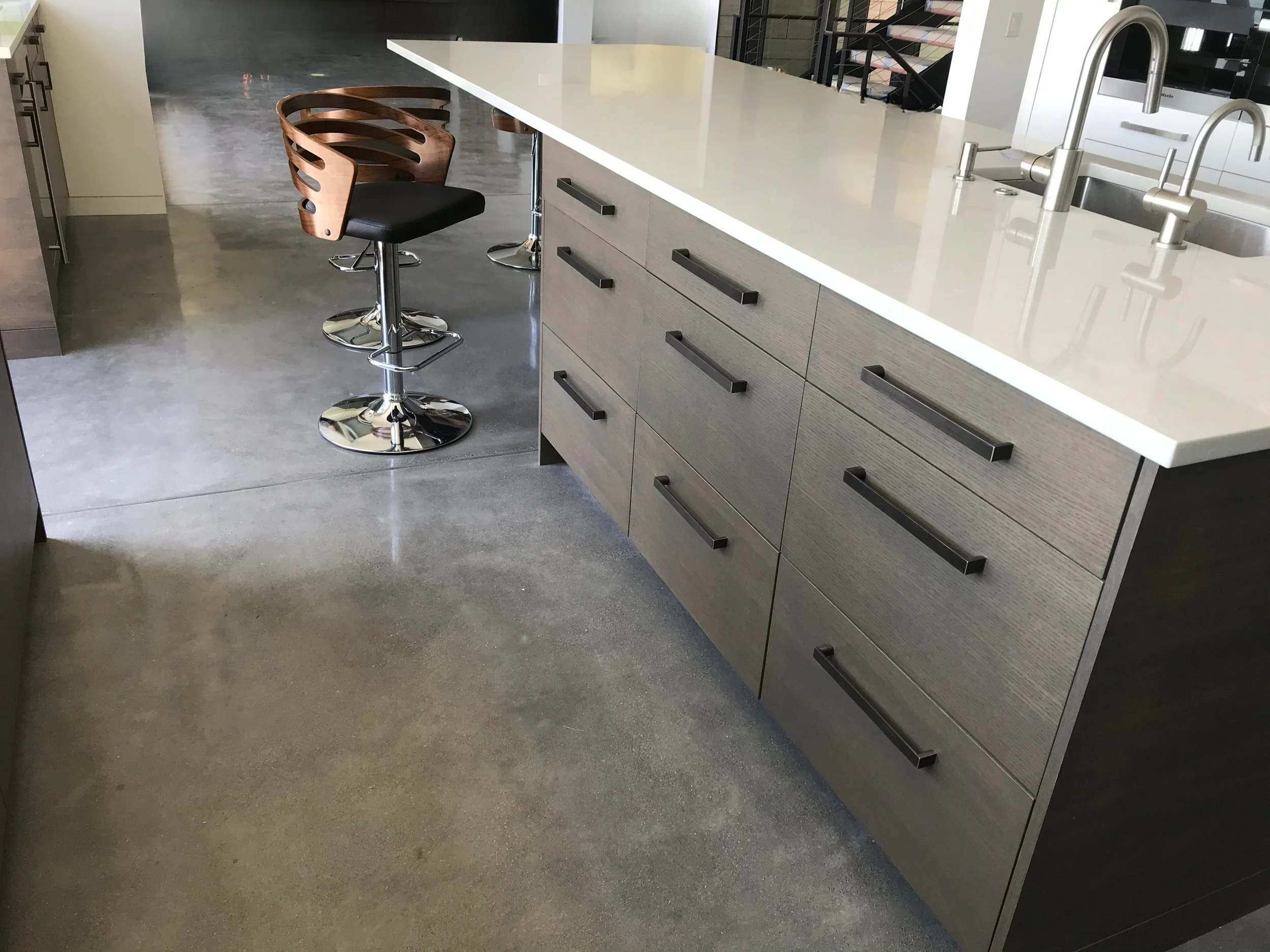 Large kitchen island with deep drawer storage, integrated sink, and waterfall-look quartz edge—Noah & Noble modern cabinets.
