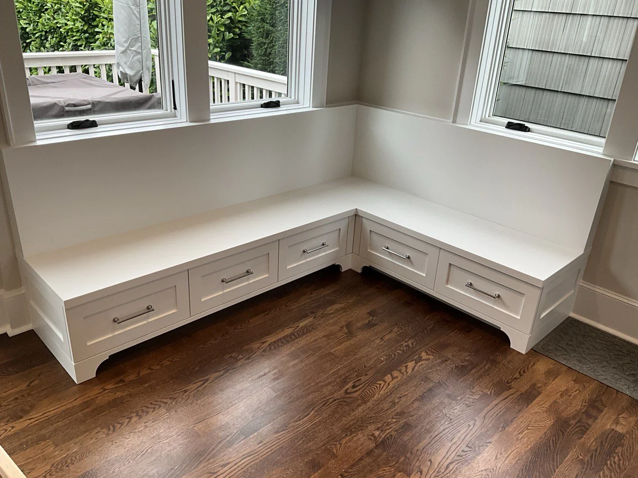 L-shaped custom banquette with shaker drawer fronts and polished pulls—under-seat storage and back panel—by Noah & Noble, Greater Seattle.