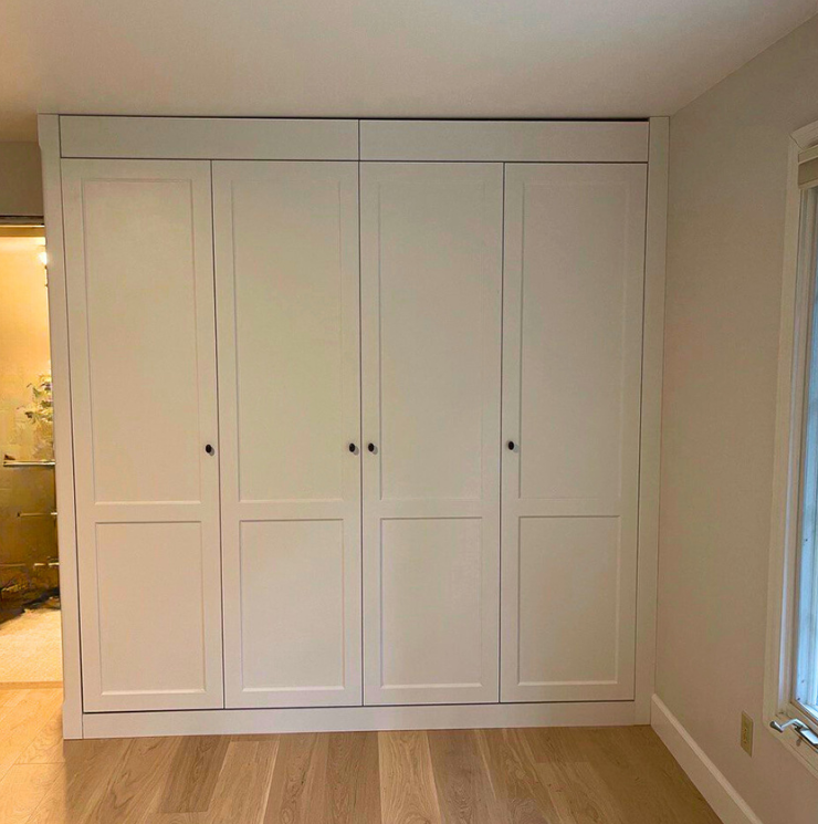 Wall-to-wall built-in wardrobe with white shaker doors and minimalist knobs—Noah & Noble, Greater Seattle.
