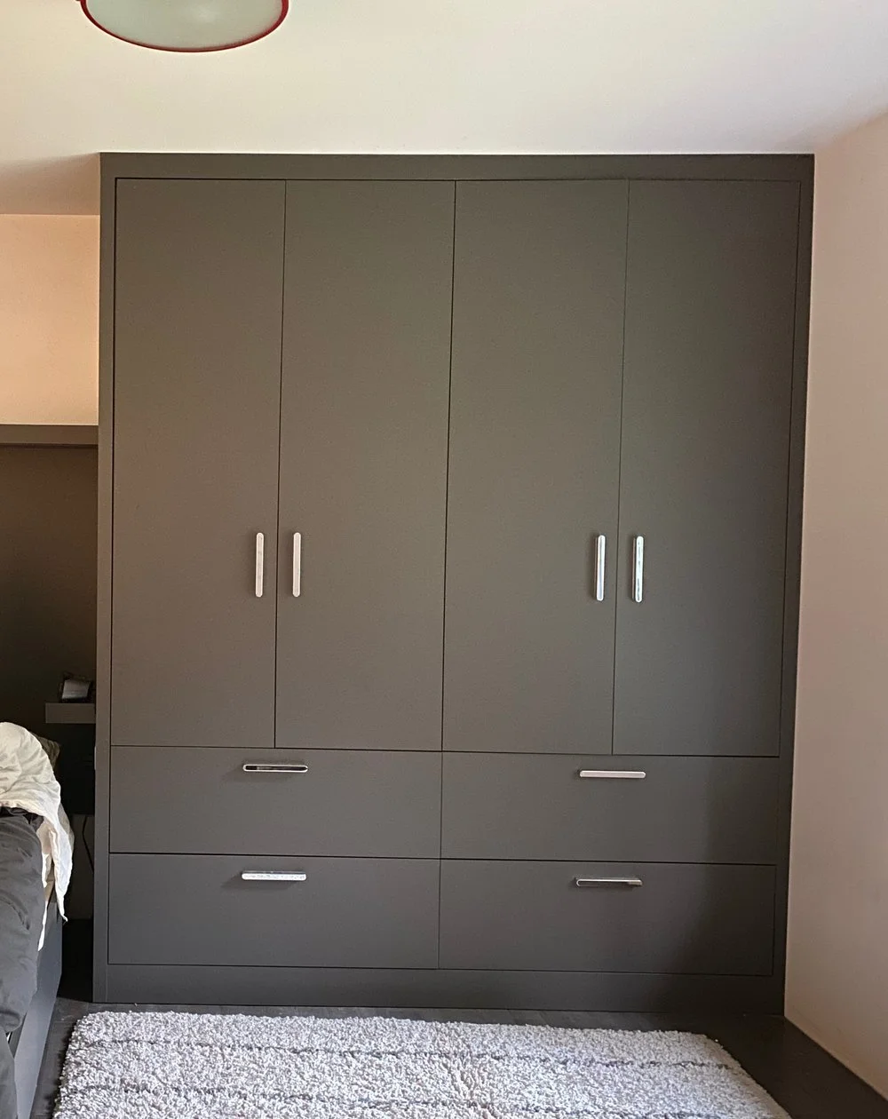Modern reach-in closet system for a teenager’s room: flat-panel gray doors, full-height storage, and soft-close drawers—crafted by Noah & Noble.