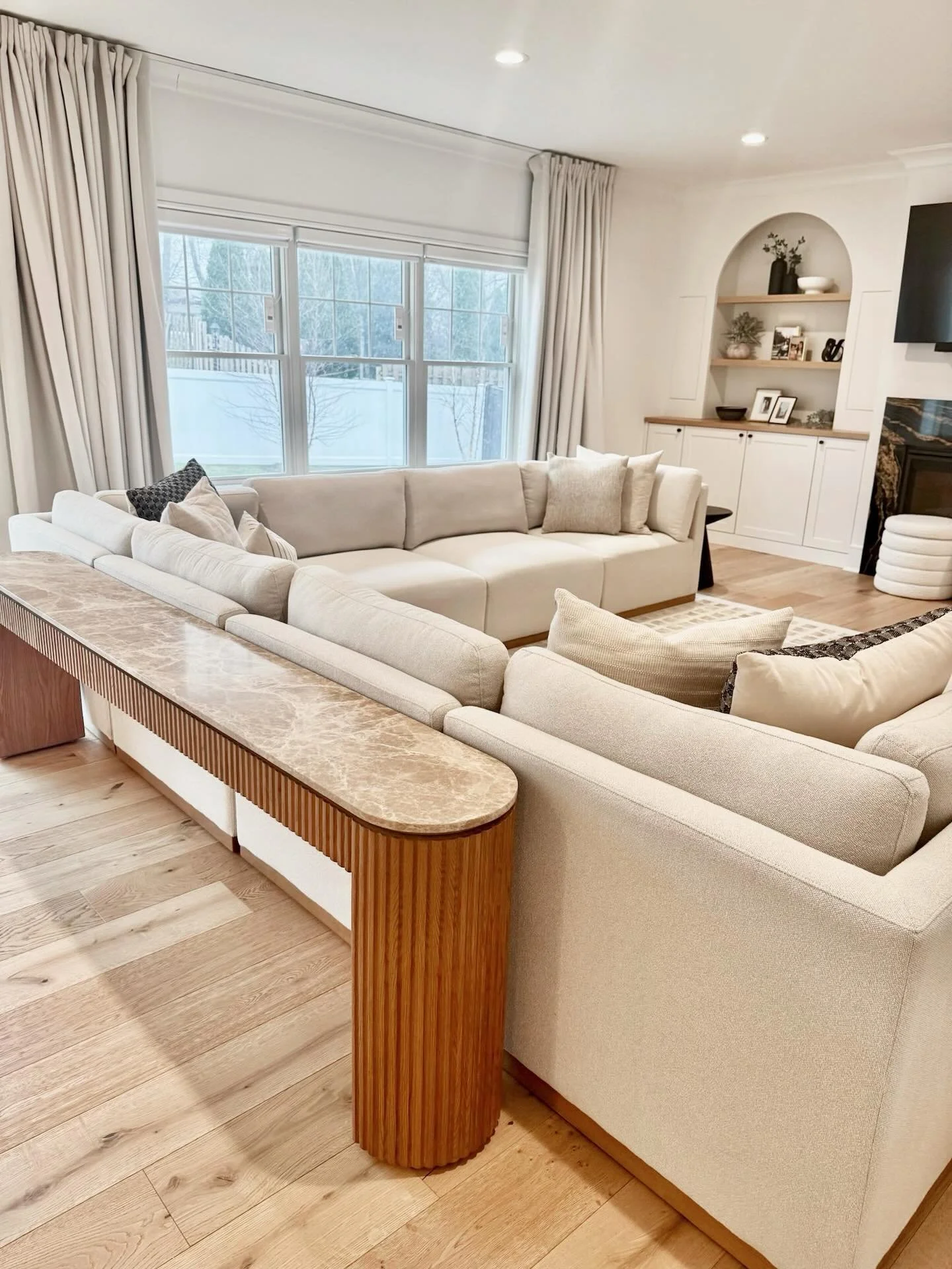 This room started with the RH sofa console.

An investment piece that instantly brought a sense of luxury, its marble top and fluted detailing anchor the sectional and define the layout. It helped define the seating arrangement and gave the open floo