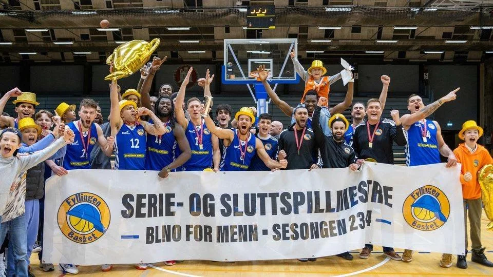 Et basketballagronomifølget lagetter opp til et lagbilde, alle smiler og har jubel, og de holder en banner som sier 'Serial- og sluttspillmestre' for sesongen 23-24, med en basketball og en trofé.