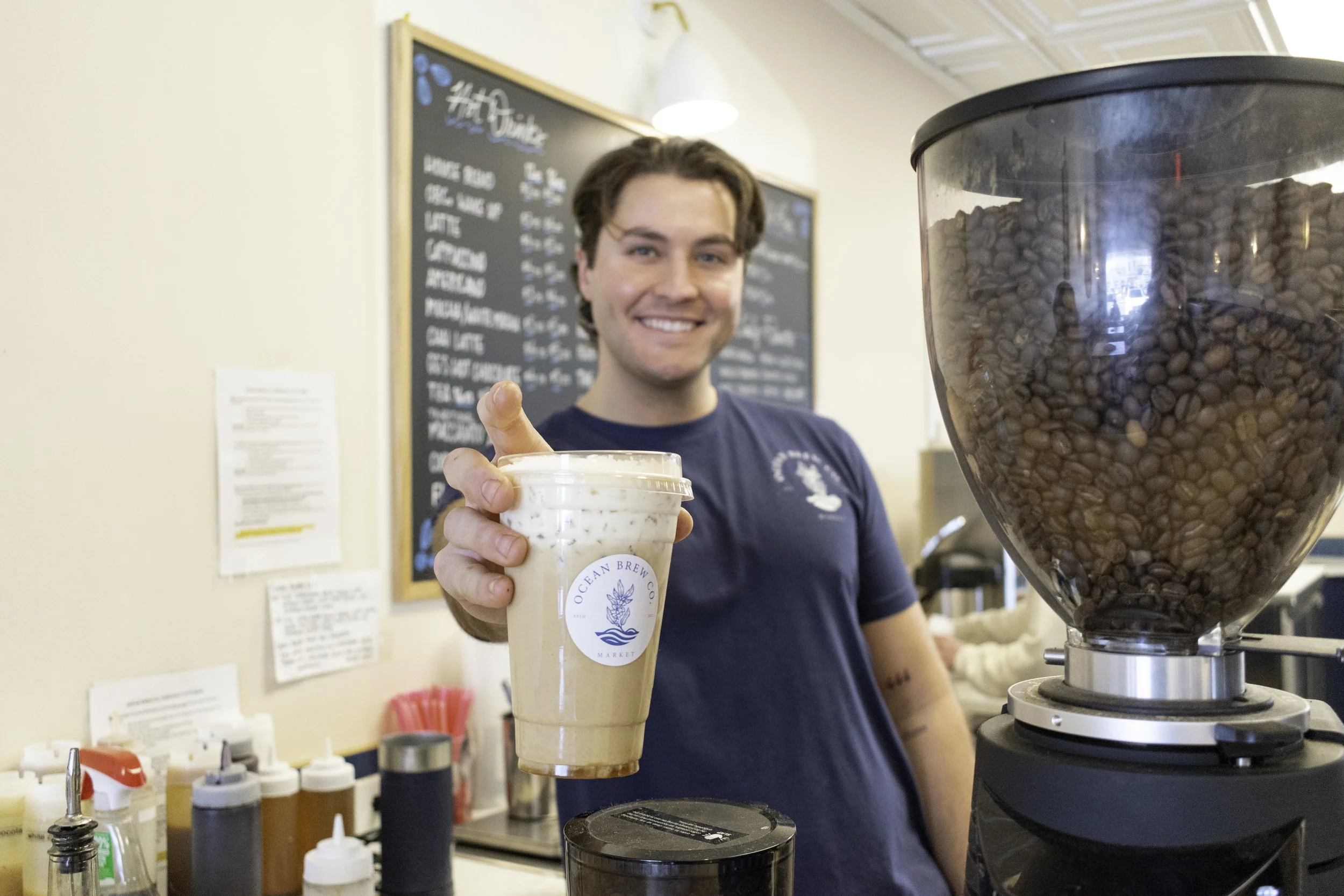 Ocean Brew Co barista holding freshly made coffee in Ocean Township NJ