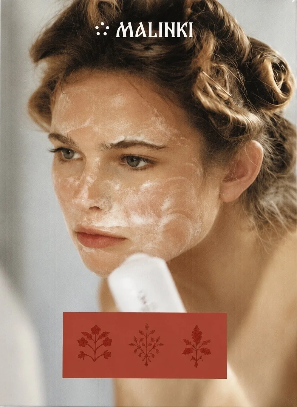 Malinki portrait of a woman in hair rollers with skincare on her face