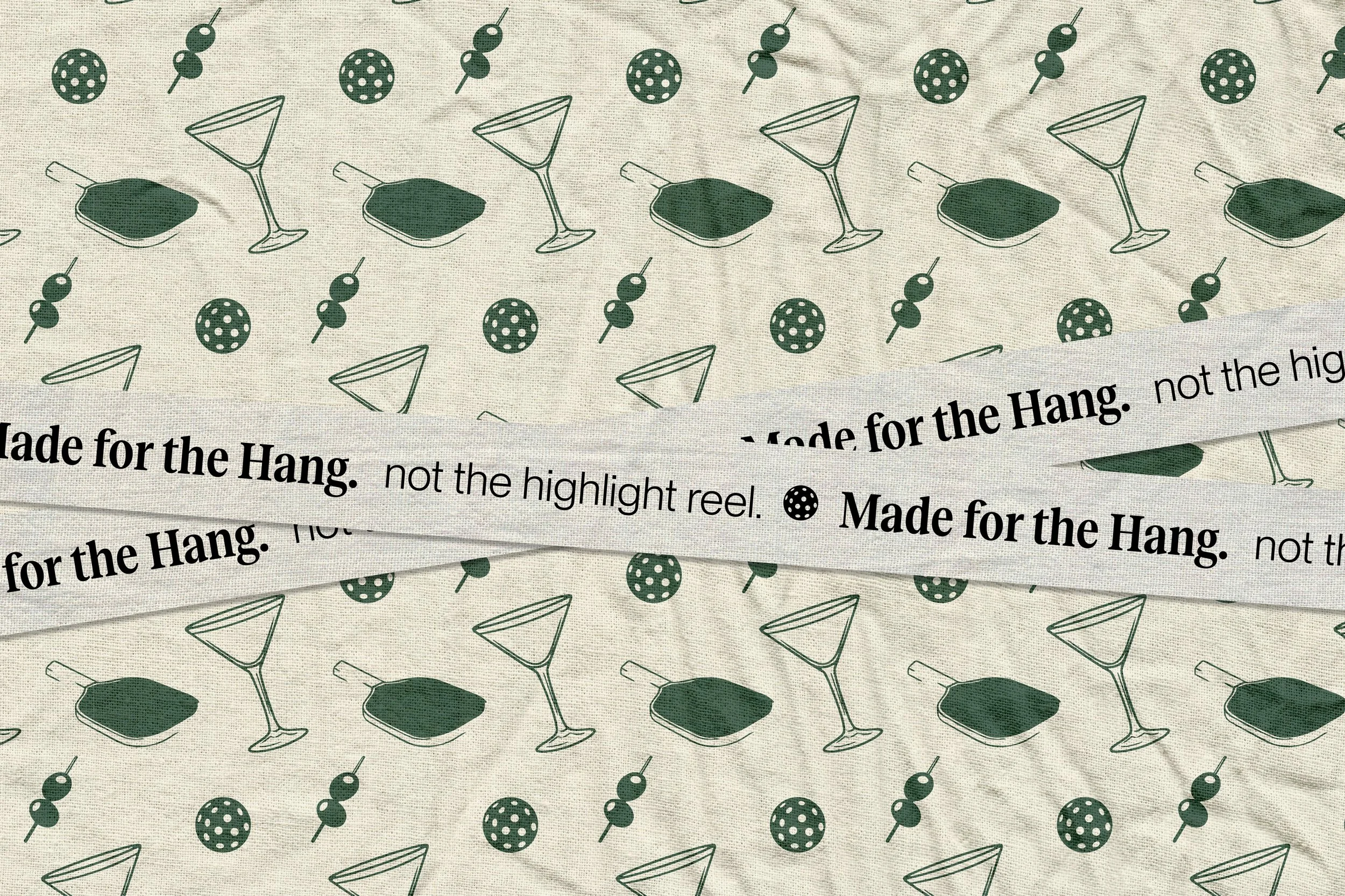 Fabric with tequila drink glasses, olives, and paper umbrellas pattern, with ribbon tags that read 'Made for the Hang. not the highlight reel.'