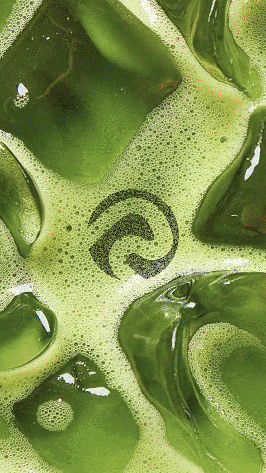 Green liquid with ice cubes and bubbles, likely a cold beverage.