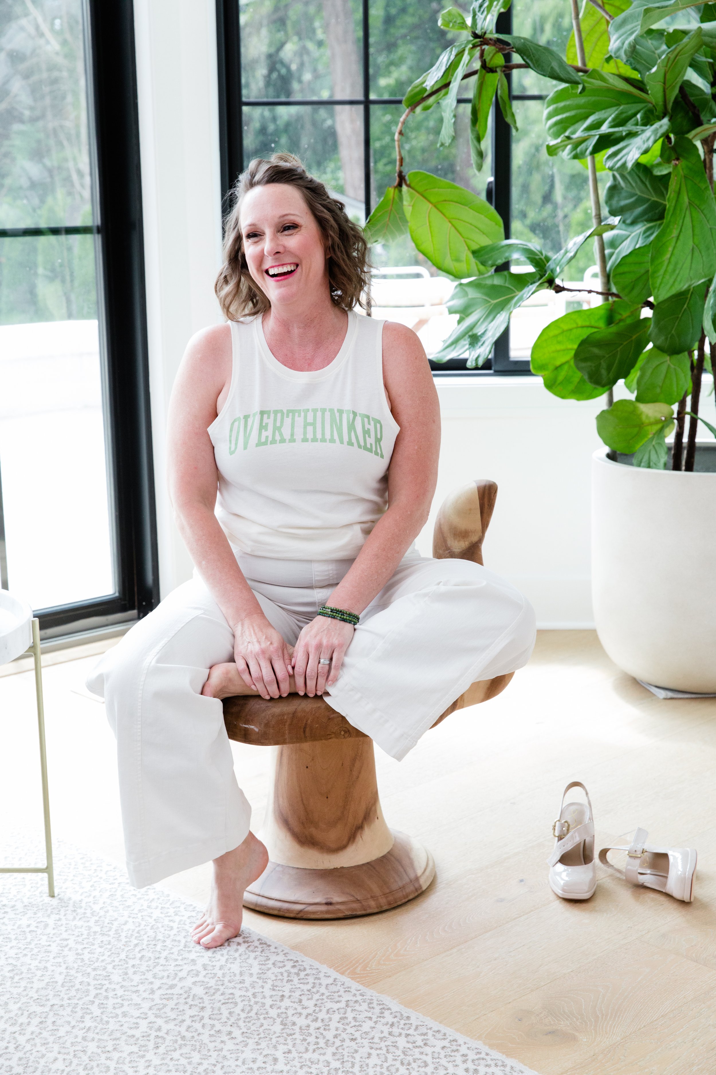 Tammy Shultz laughing in a bright Olympia therapy studio, wearing an ‘Overthinker’ tank top — a warm, relatable moment used on the Anxiety Therapy page.”
