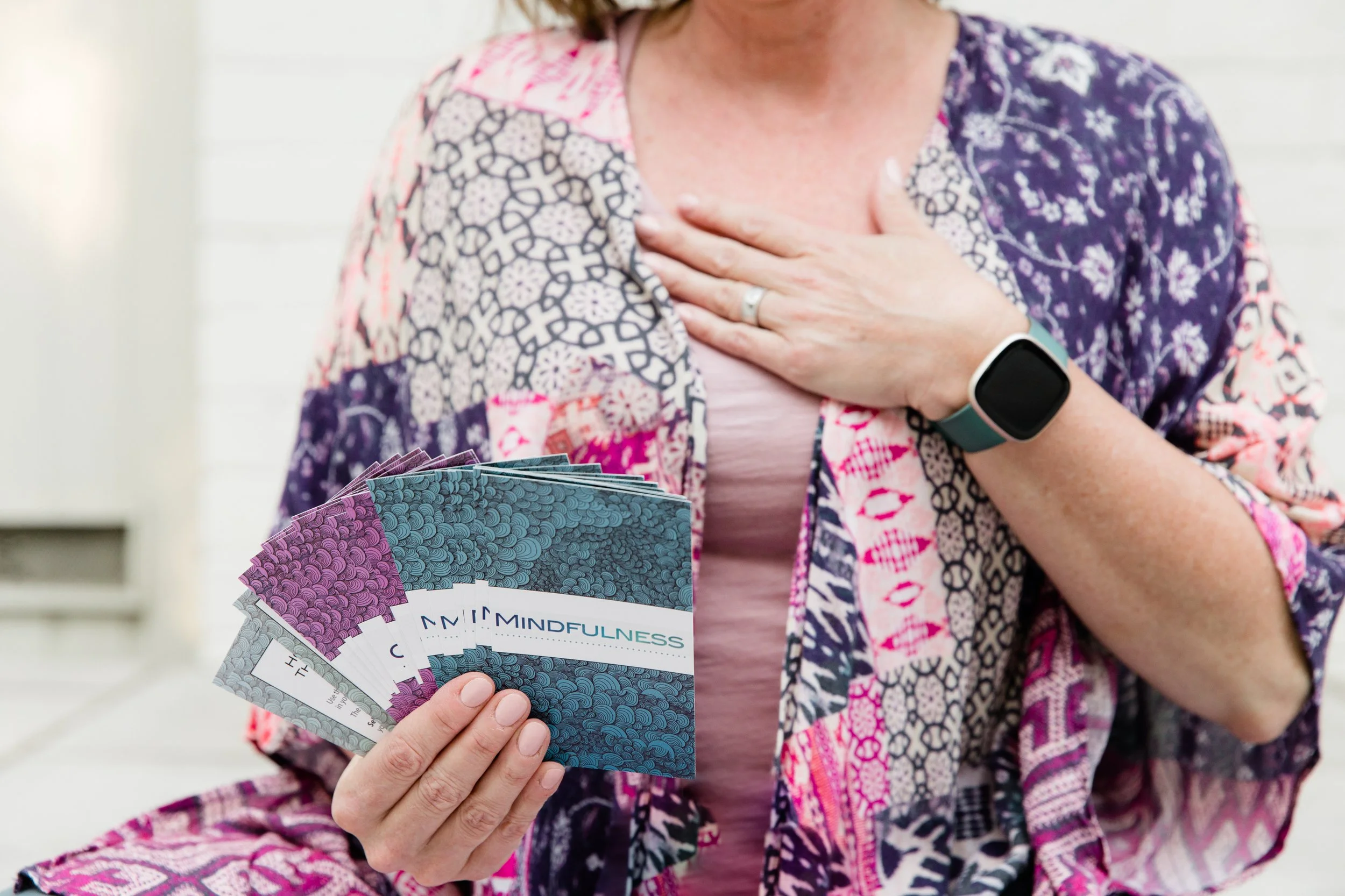 Tammy Shultz holding mindfulness cards with a hand over her heart, reflecting grounded support for emotional clarity and inner steadiness.