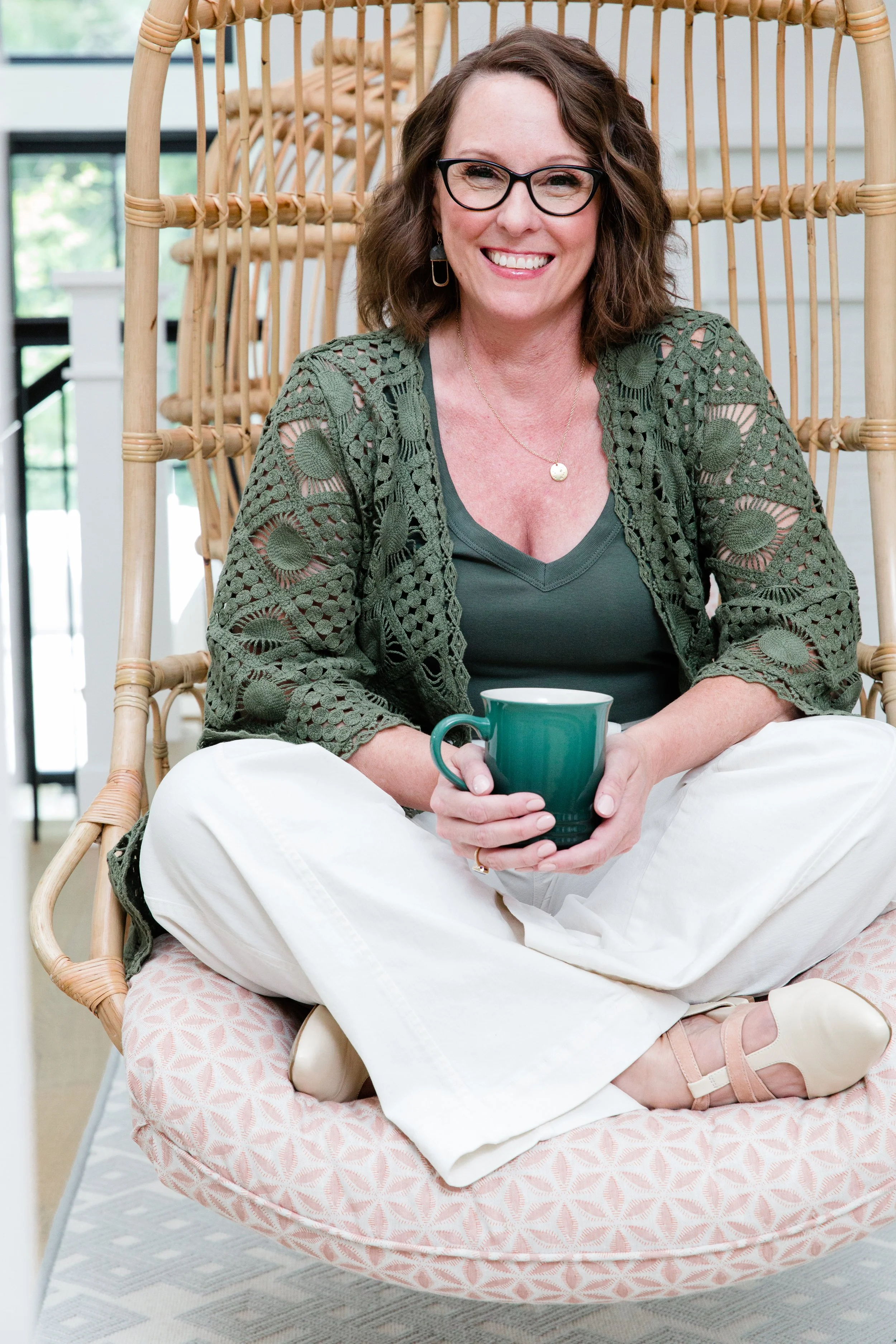 Tammy Shultz sitting comfortably with a coffee mug in her Olympia office, modeling a calm, grounded presence for clients seeking anxiety therapy across Washington.