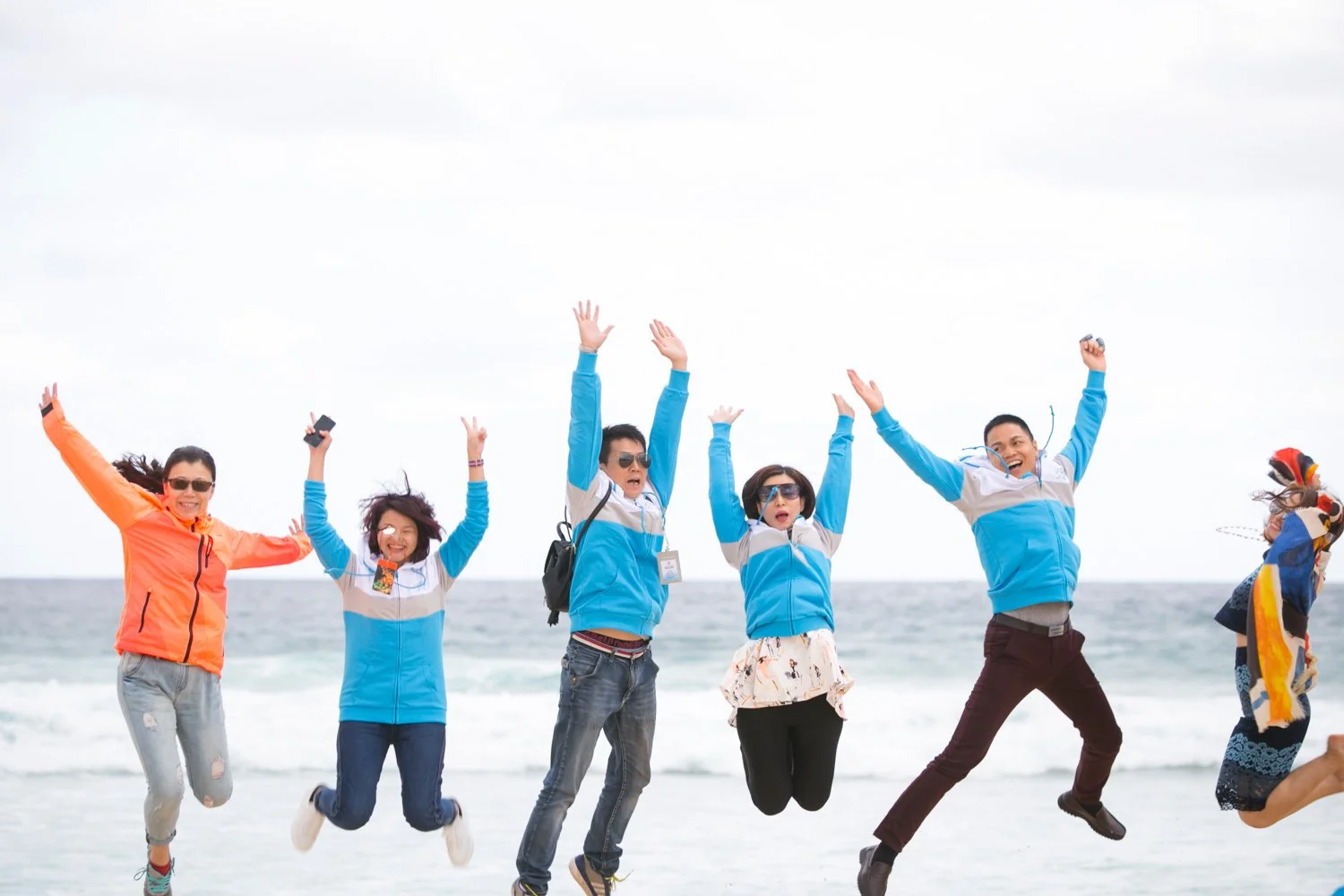 International conference delegates jump for joy during a Gold Coast beach tour
