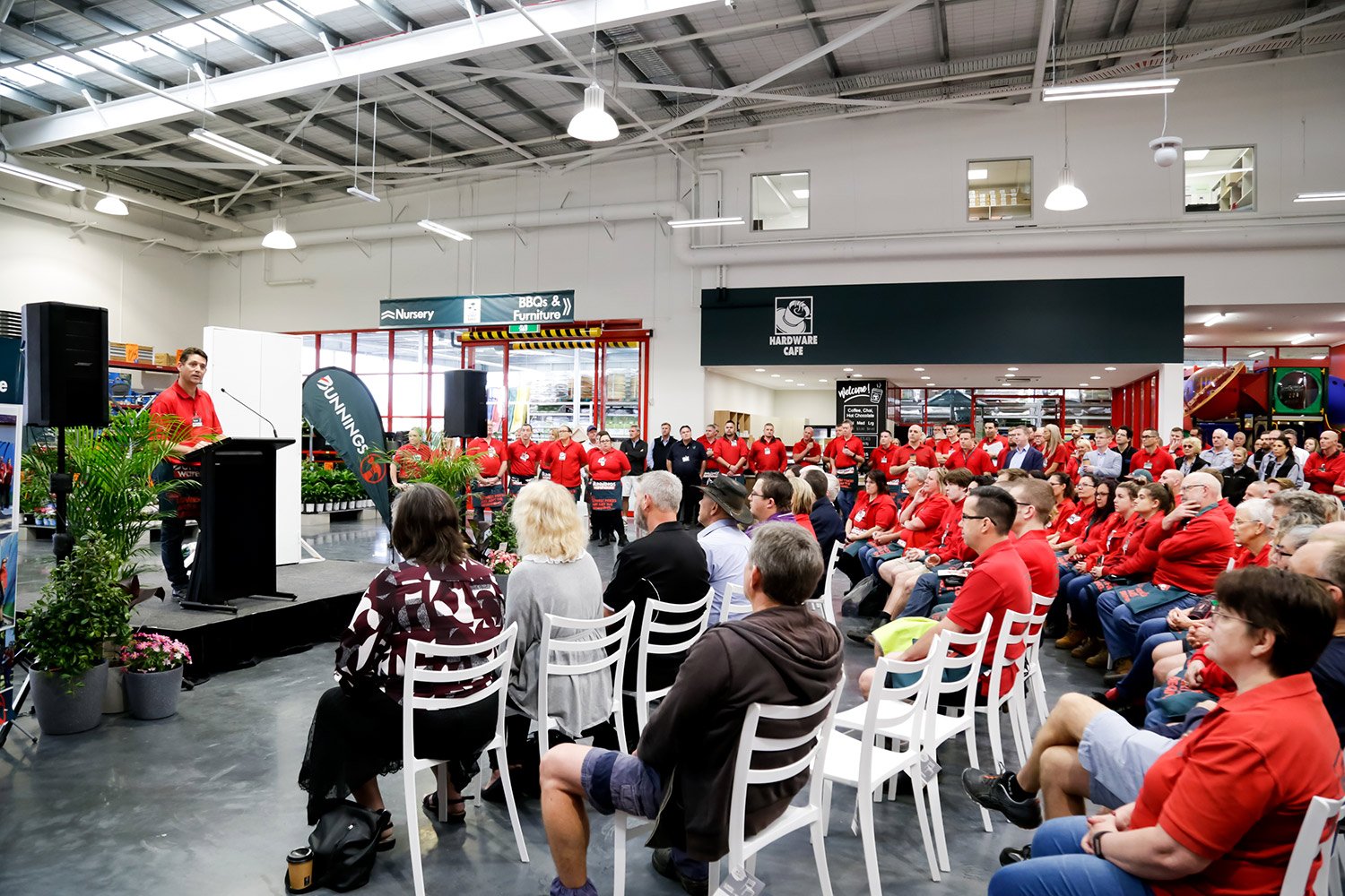 Speaker addressing audience at retail opening event