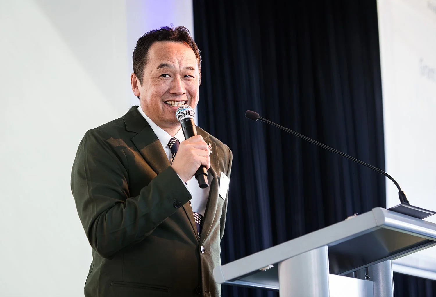 Speaker delivering a lighthearted speech during a conference in Brisbane