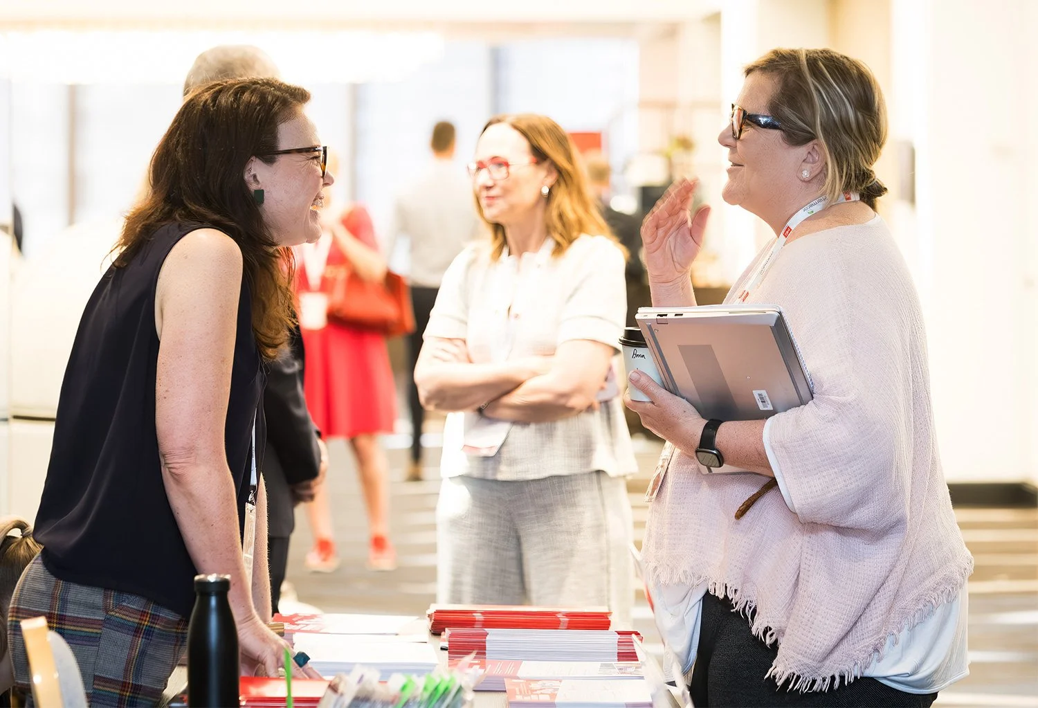 Conference staff member welcoming attendee at registration desk