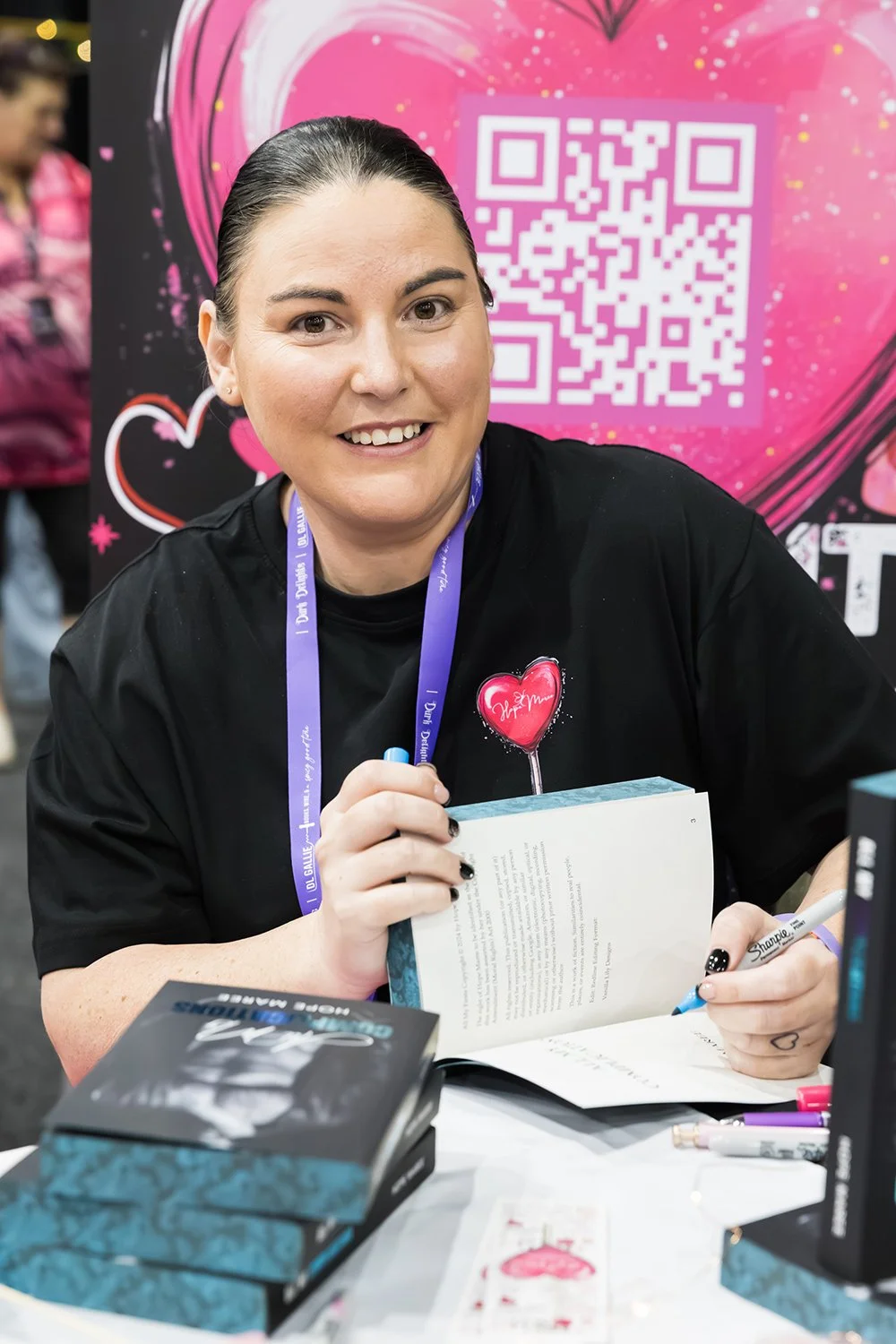 Exhibitor signs book at Brisbane book signing expo
