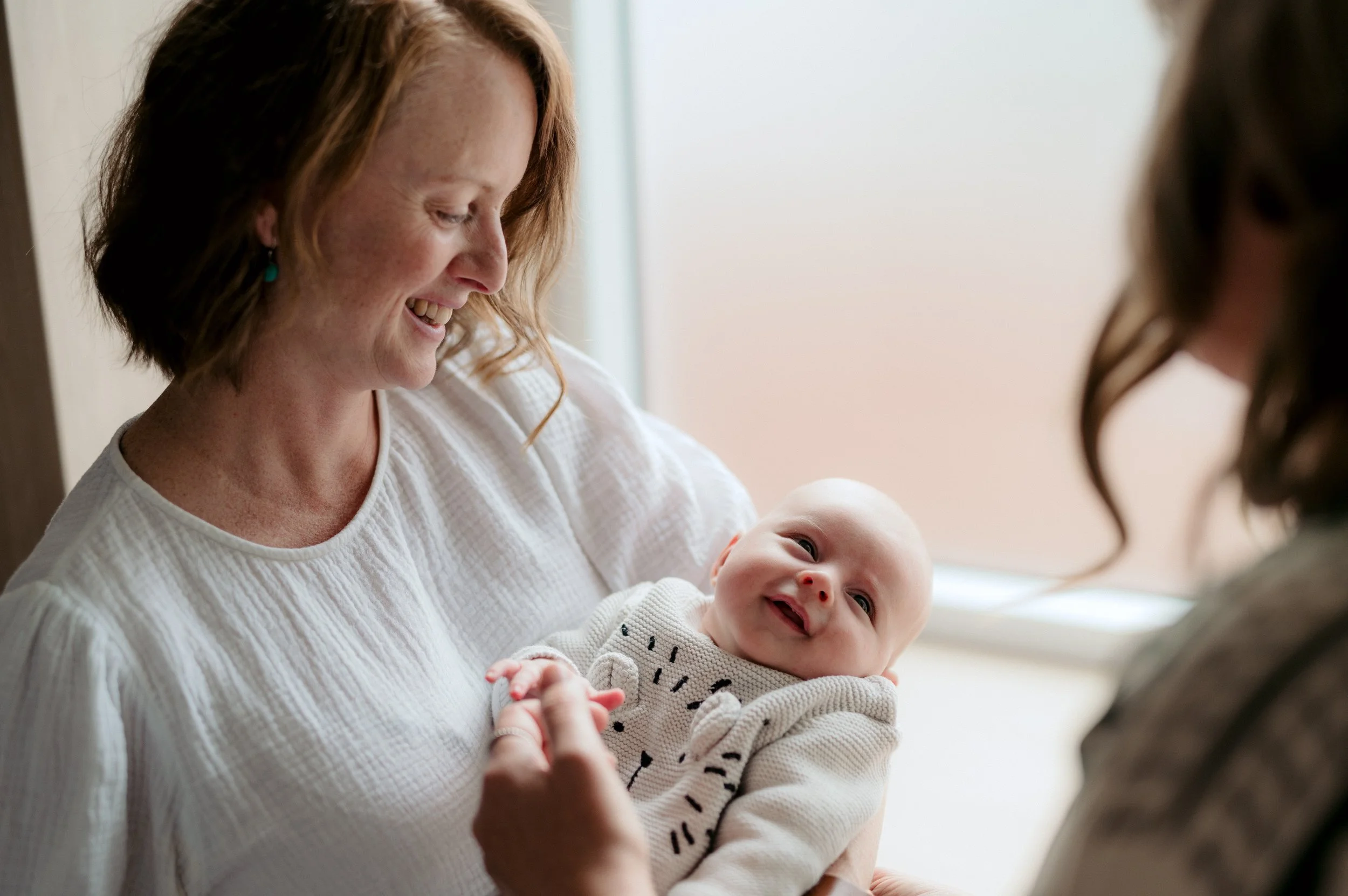 mother smiling at her laughing baby in her arms