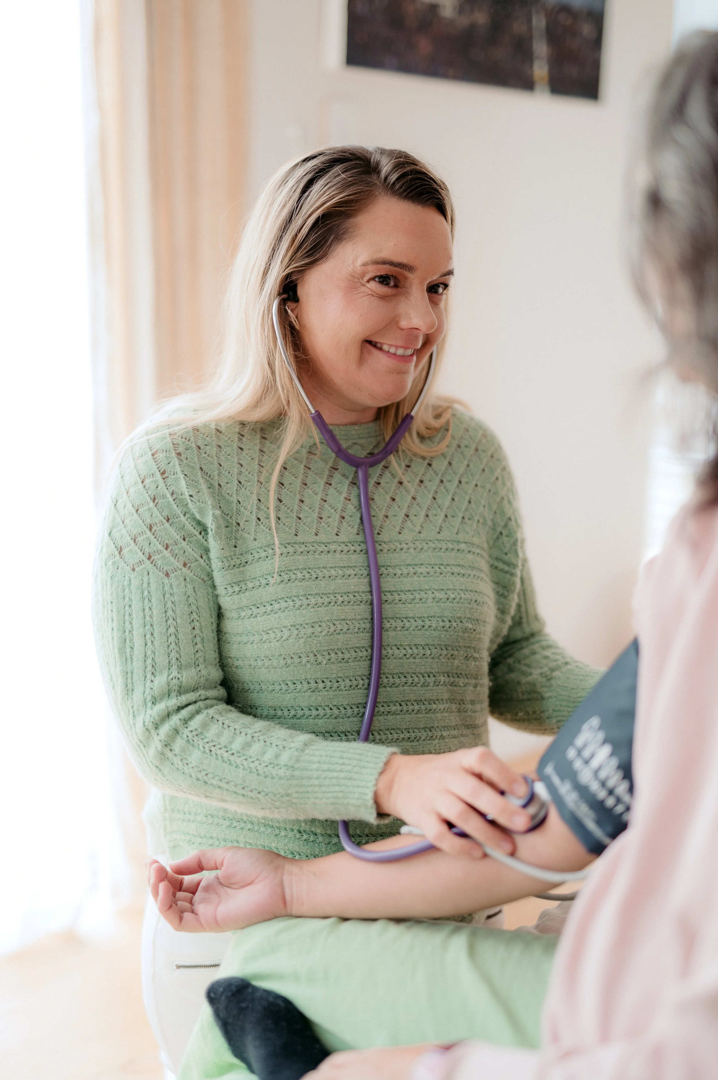 midwife manually checking pregnant patients blood pressure