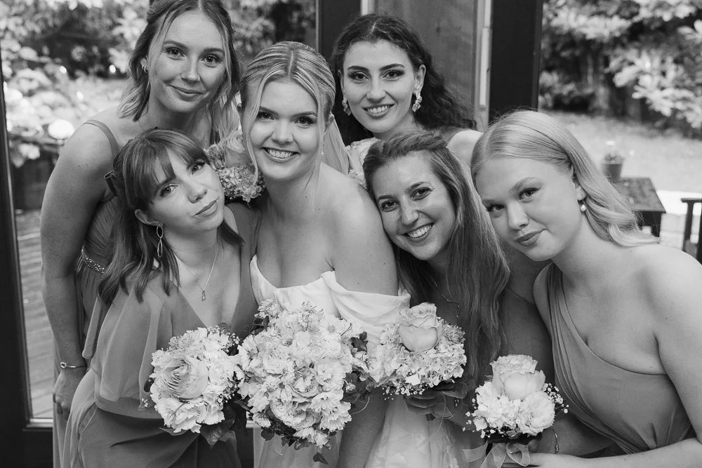 Bride smiling with bridesmaids holding bouquets at wedding in Hamburg
