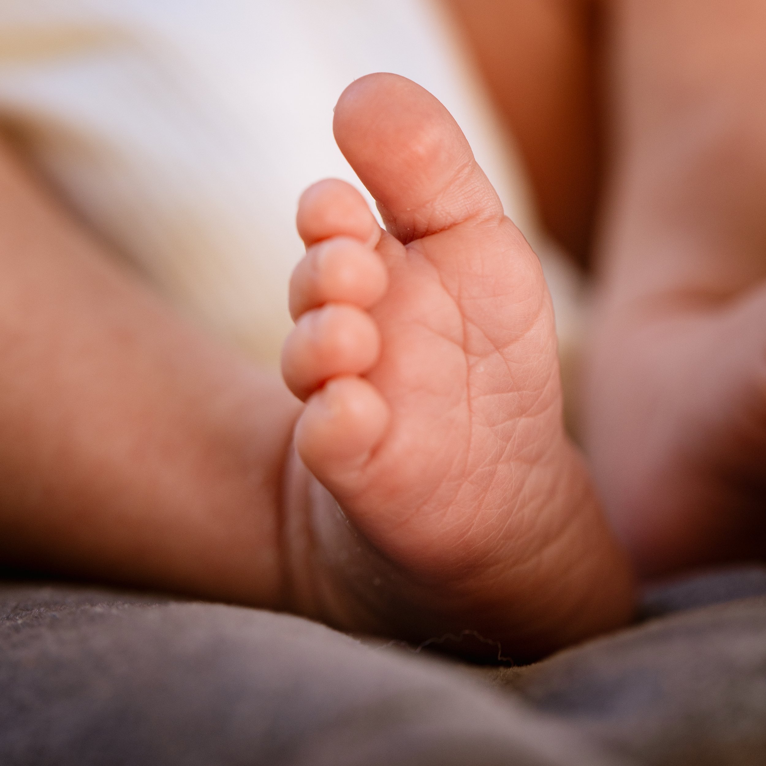 Close-up view of an infant's foot, touching a surface