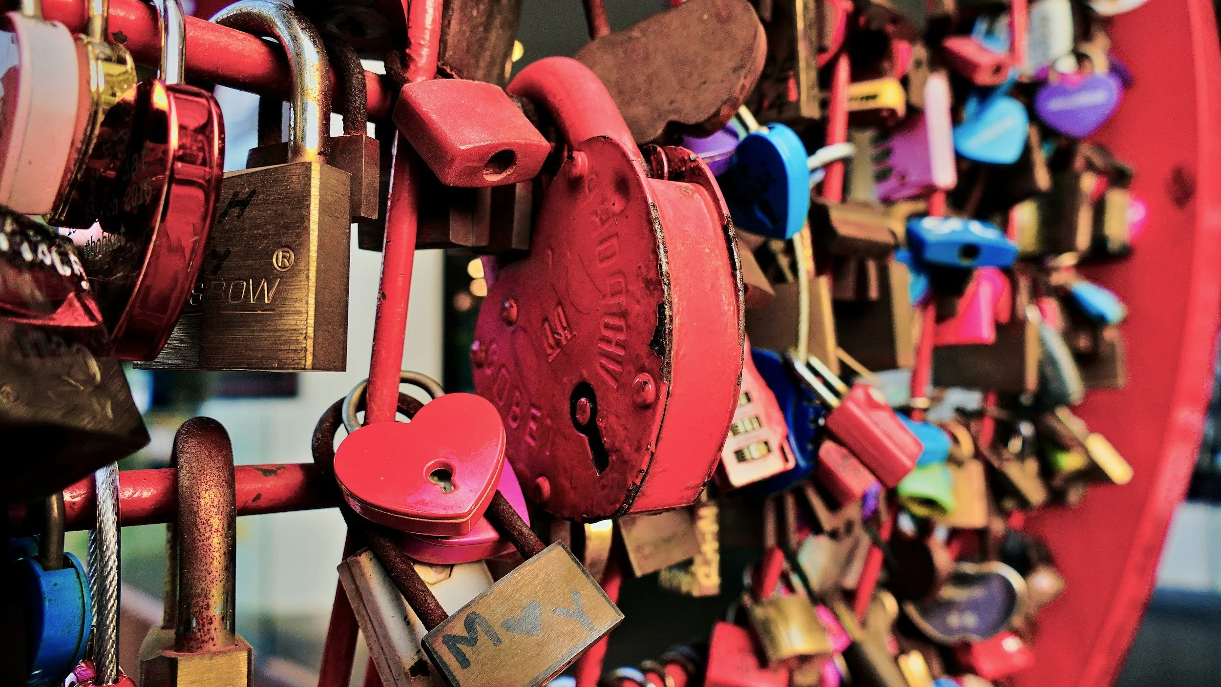 Cadenas, cadenas de amor, en distintos colores y tamaños, attachés a una estructura metálica de color rojo